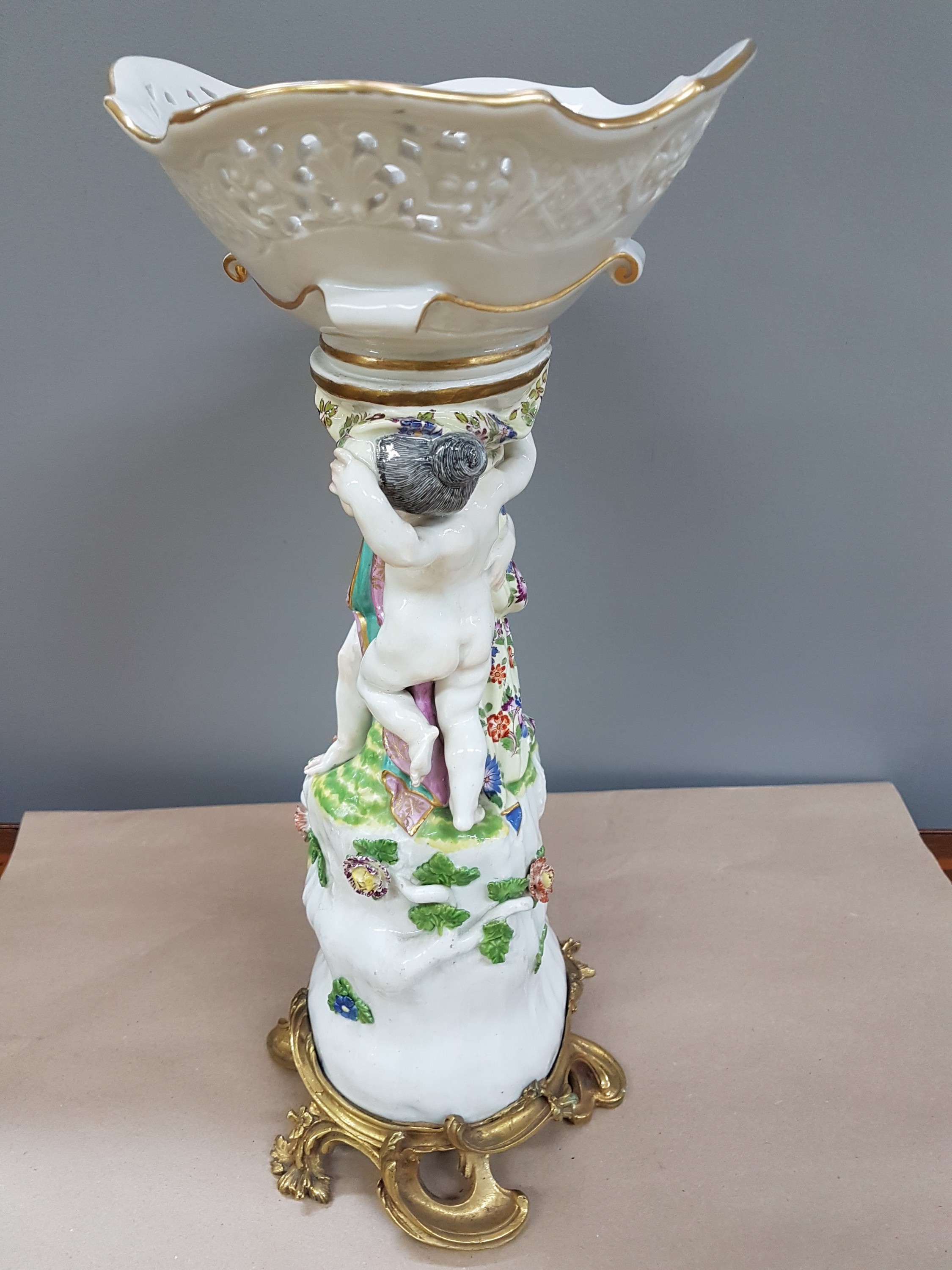 Detail e: Figürlicher Tafelaufsatz, Meissen, um 1740, zwei Putten auf stammähnlichem Sockel stehend mit Geäst und applizierten Blüten, Korbschale mit ...