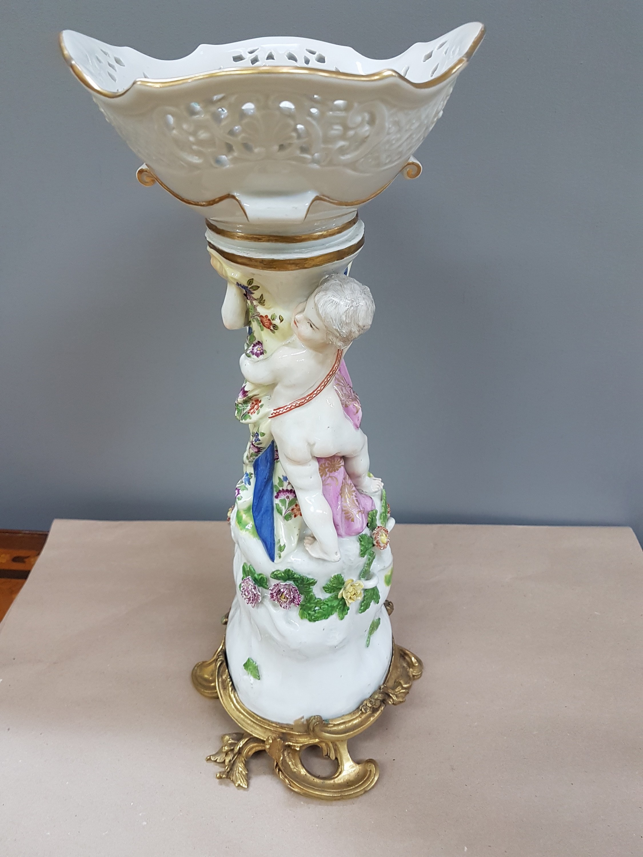 Detail j: Figürlicher Tafelaufsatz, Meissen, um 1740, zwei Putten auf stammähnlichem Sockel stehend mit Geäst und applizierten Blüten, Korbschale mit ...