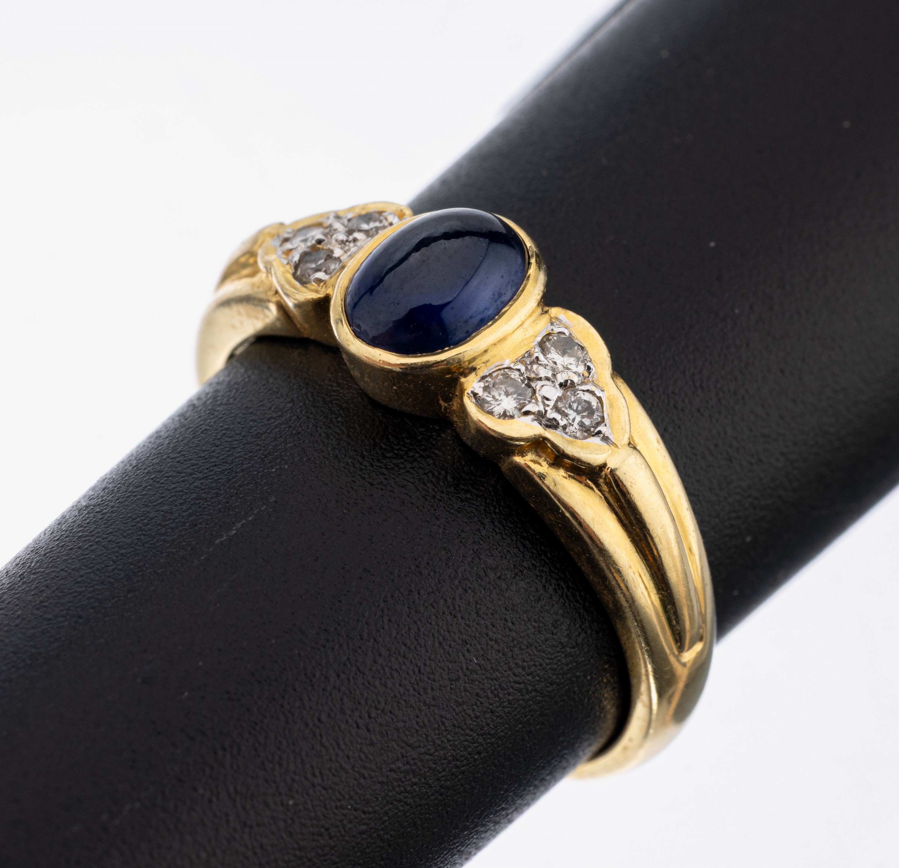18 kt Gold Saphir-Brillant-Ring, GG 750/000, mittig ovaler Saphir-Cabochon ca. 1.19 ct (grav.) 6 Brillanten zus. ca. 0.13 ct (grav.) Weiß/si, RW ...