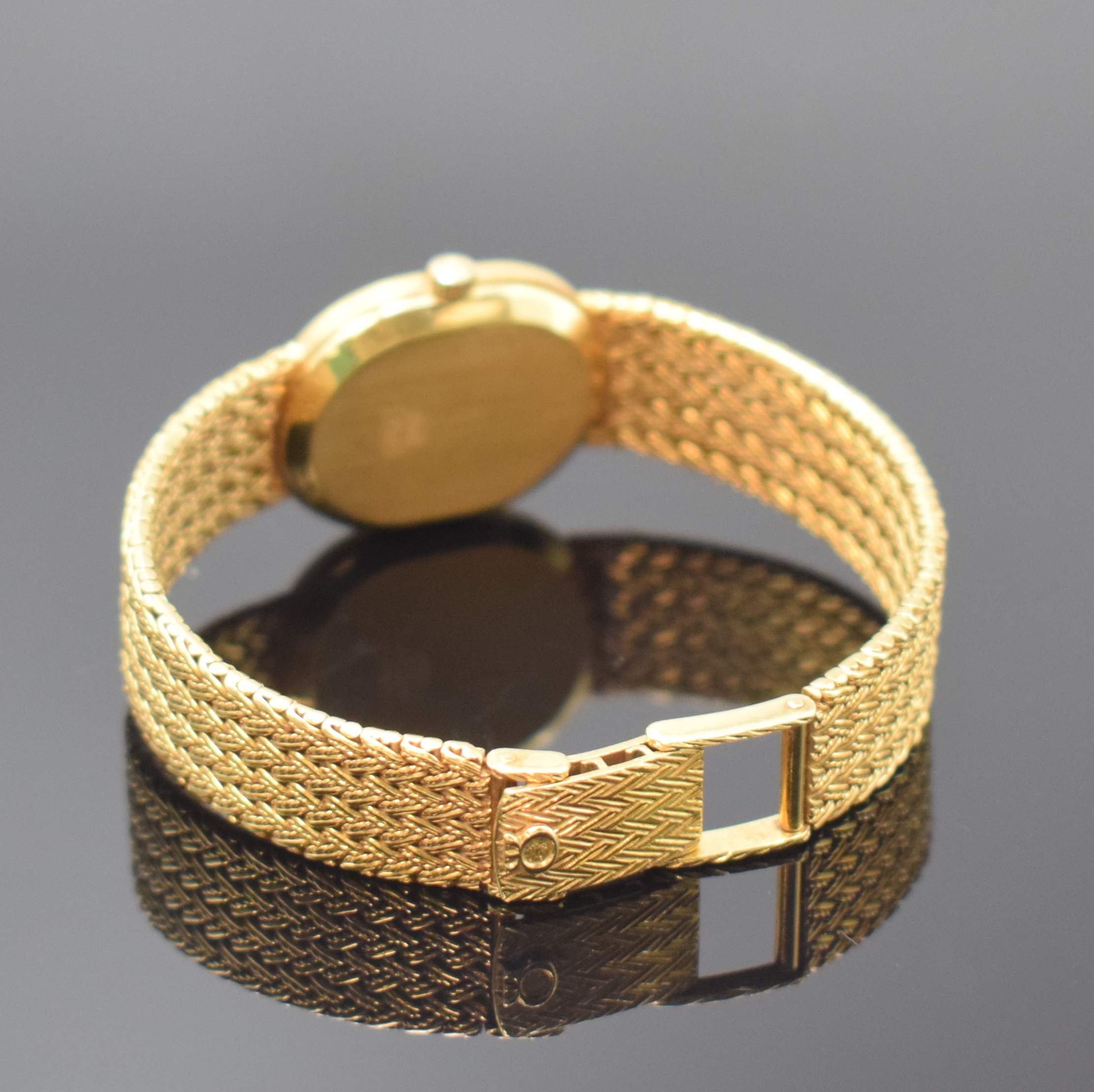 Detail b: MILUS Damenarmbanduhr in GG 750/000, Schweiz um 1975, quarz, Boden aufgedr., orig. Gold- Flechtband, gold. Zifferbl. m. schwarzen Zeigern, M. 27 x ...