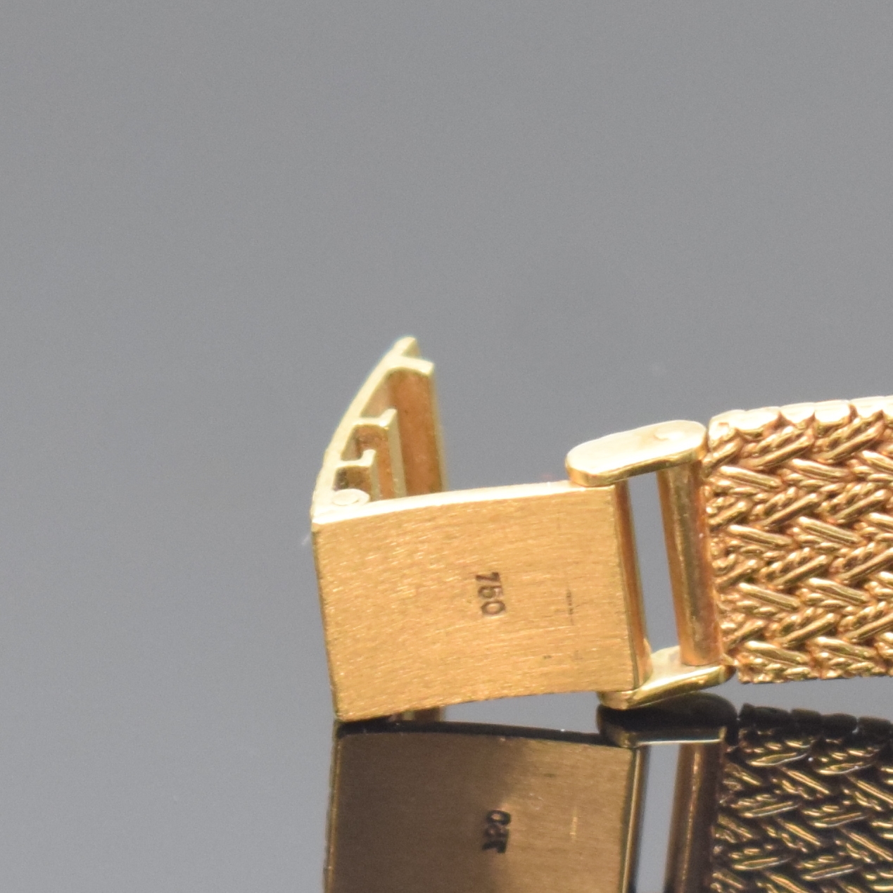 Detail c: MILUS Damenarmbanduhr in GG 750/000, Schweiz um 1975, quarz, Boden aufgedr., orig. Gold- Flechtband, gold. Zifferbl. m. schwarzen Zeigern, M. 27 x ...