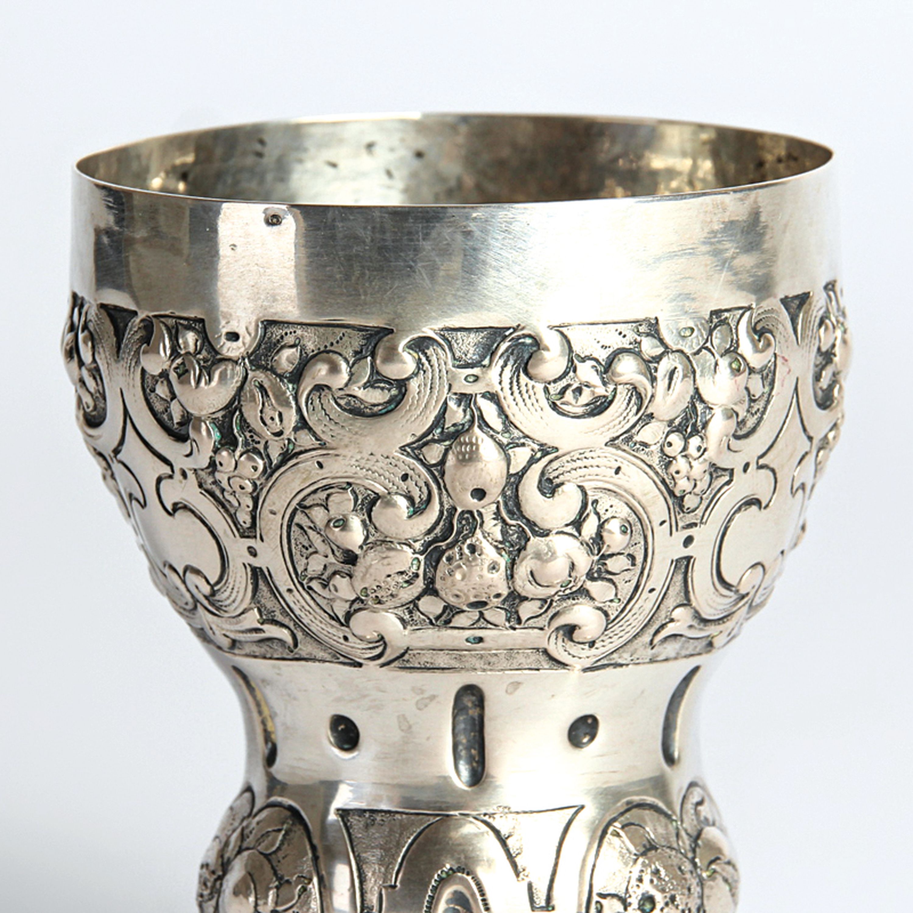 Detail a: Kugelfußbecher, Nürnberg, 18.Jh., 13 Lot Silber, Dekor mit Rollwerk und Früchten, auf drei großen Kugelfüßen, 119g, H. 10 cm, Meistermarke N