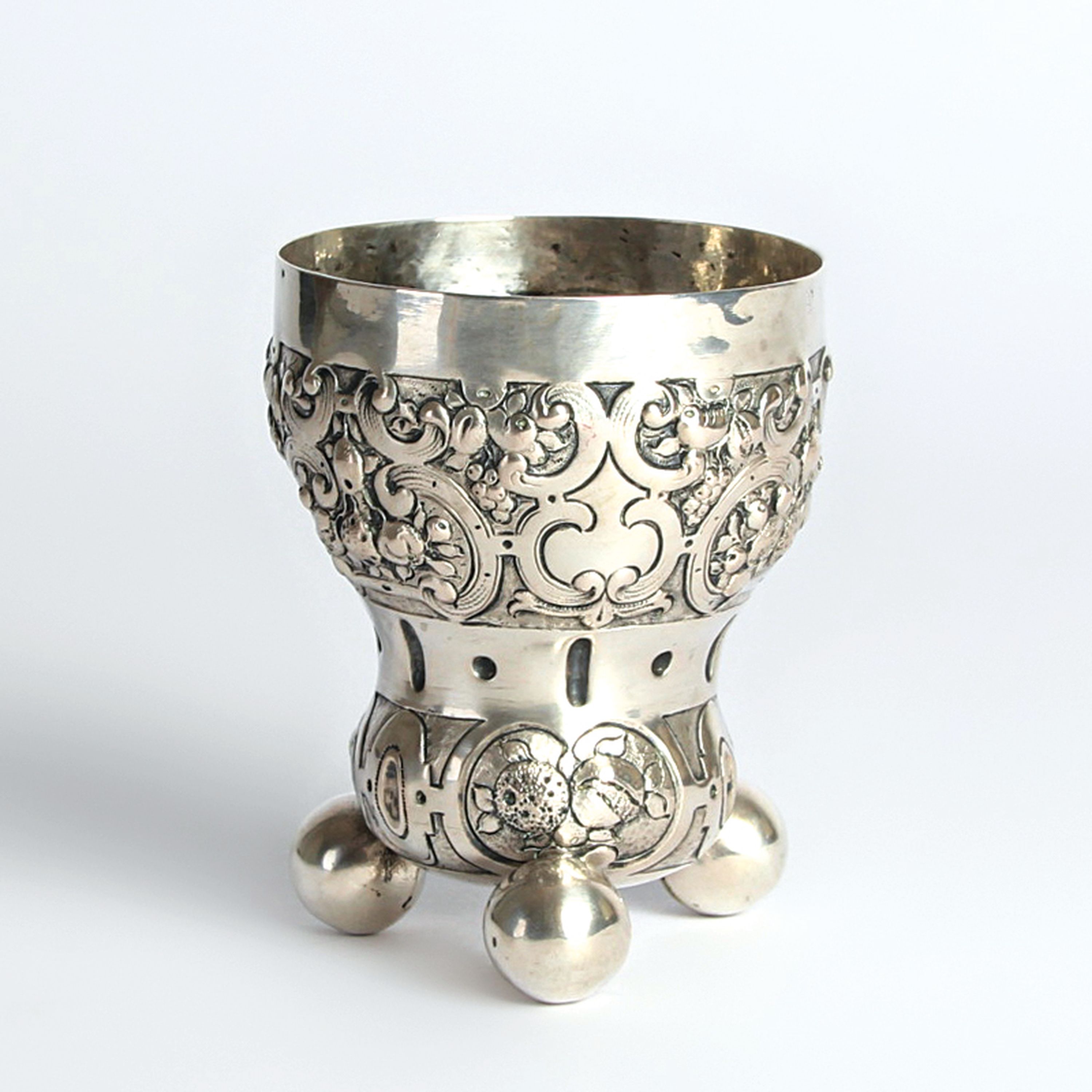 Detail c: Kugelfußbecher, Nürnberg, 18.Jh., 13 Lot Silber, Dekor mit Rollwerk und Früchten, auf drei großen Kugelfüßen, 119g, H. 10 cm, Meistermarke N