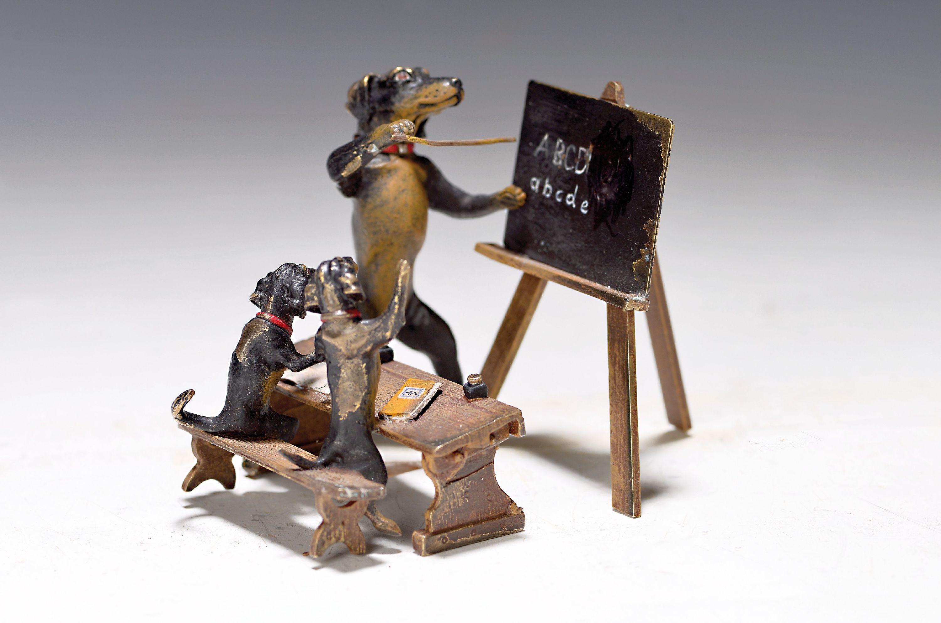 Dackelschule, Wiener Bronze, Sign. Wasserkrug, Lehrer an der Tafel mit zwei Schülern am Pult, ca. 7.5x10x8 cm