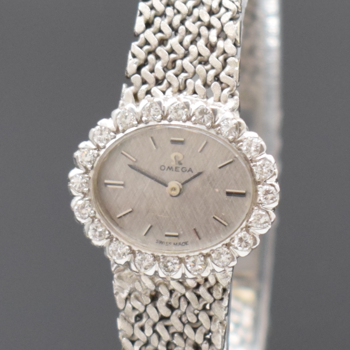 Detail a: OMEGA Damenarmbanduhr in WG 750/000 mit Diamantbesatz, Schweiz um 1969, Handaufzug, orig. Goldband, Lünette aufw. m. Diamanten bes., Boden aufgedr., ...