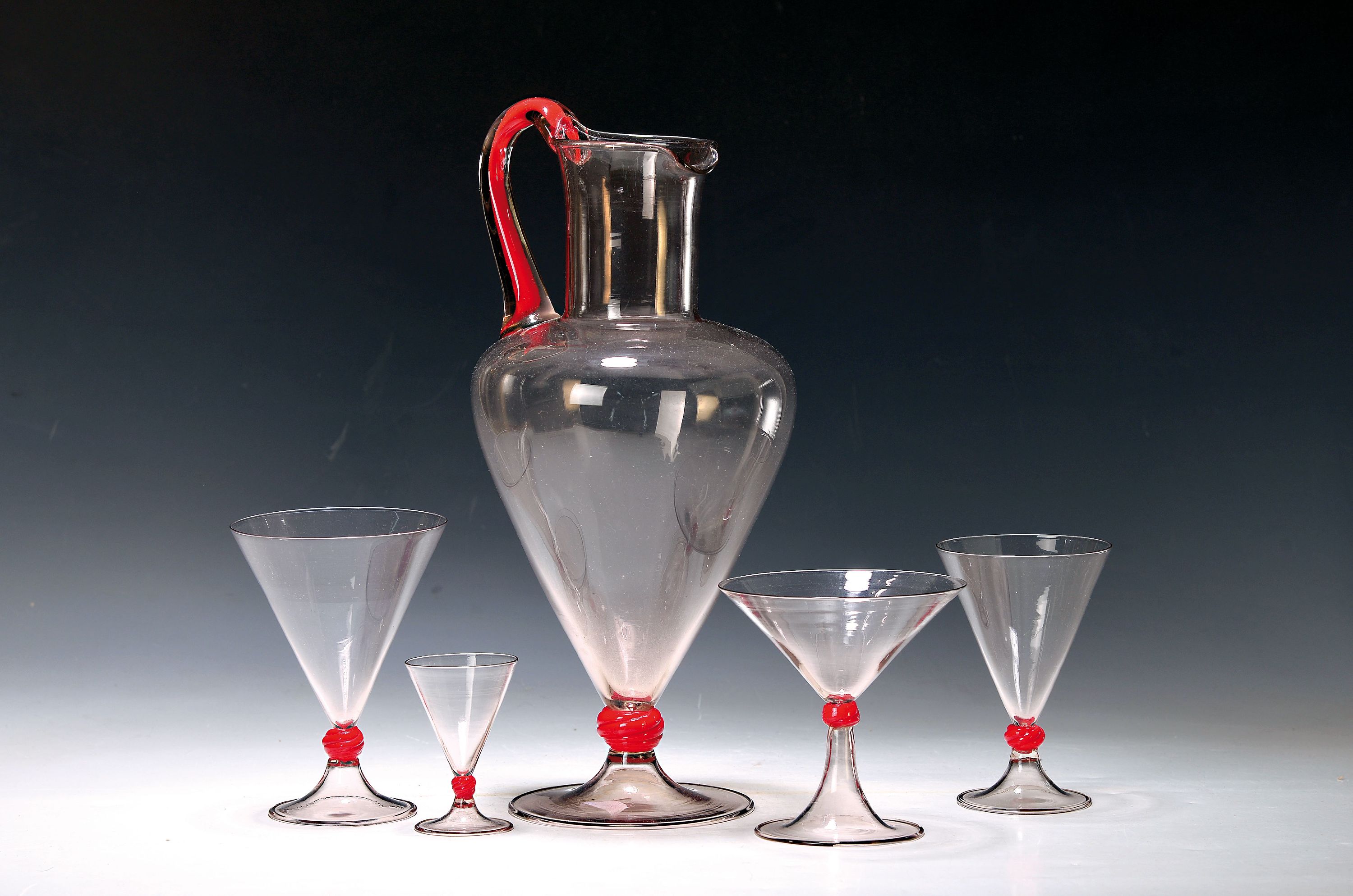 Henkelkanne und 4 Gläser, Murano, 1. Viertel 20.Jh., farbloses Glas, Henkel und Nodi mit blutroten Einschmelzungen, Kanne H. 34 cm, vier ...