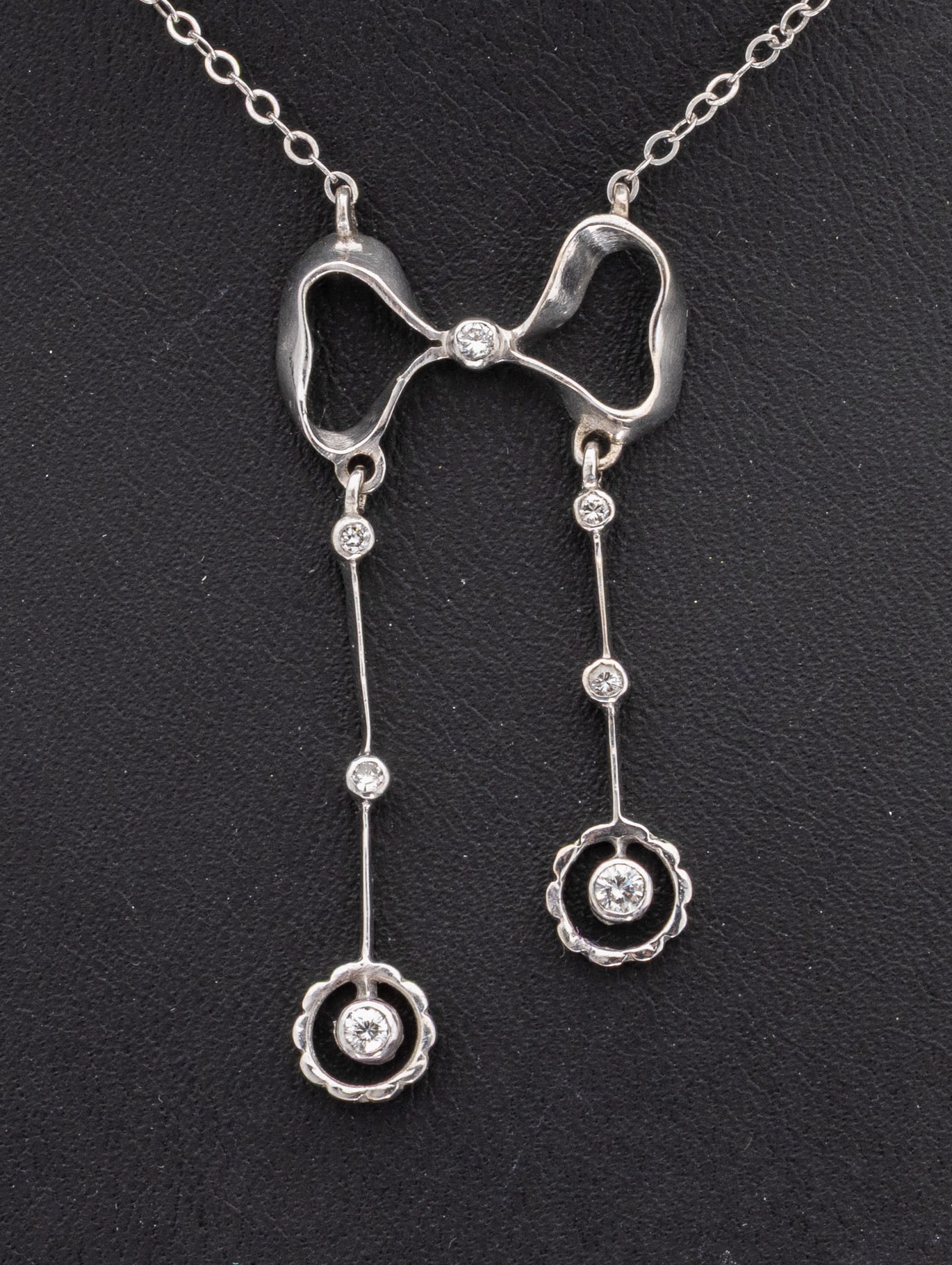Detail a: 14 kt Gold Brillant-Collier, WG 585/000, nach älterem Vorbild, schleifenförmige Mittelteil mit 2 bewegl. Abhängungen, 7 Brillanten zus. ca. 0.20 ...
