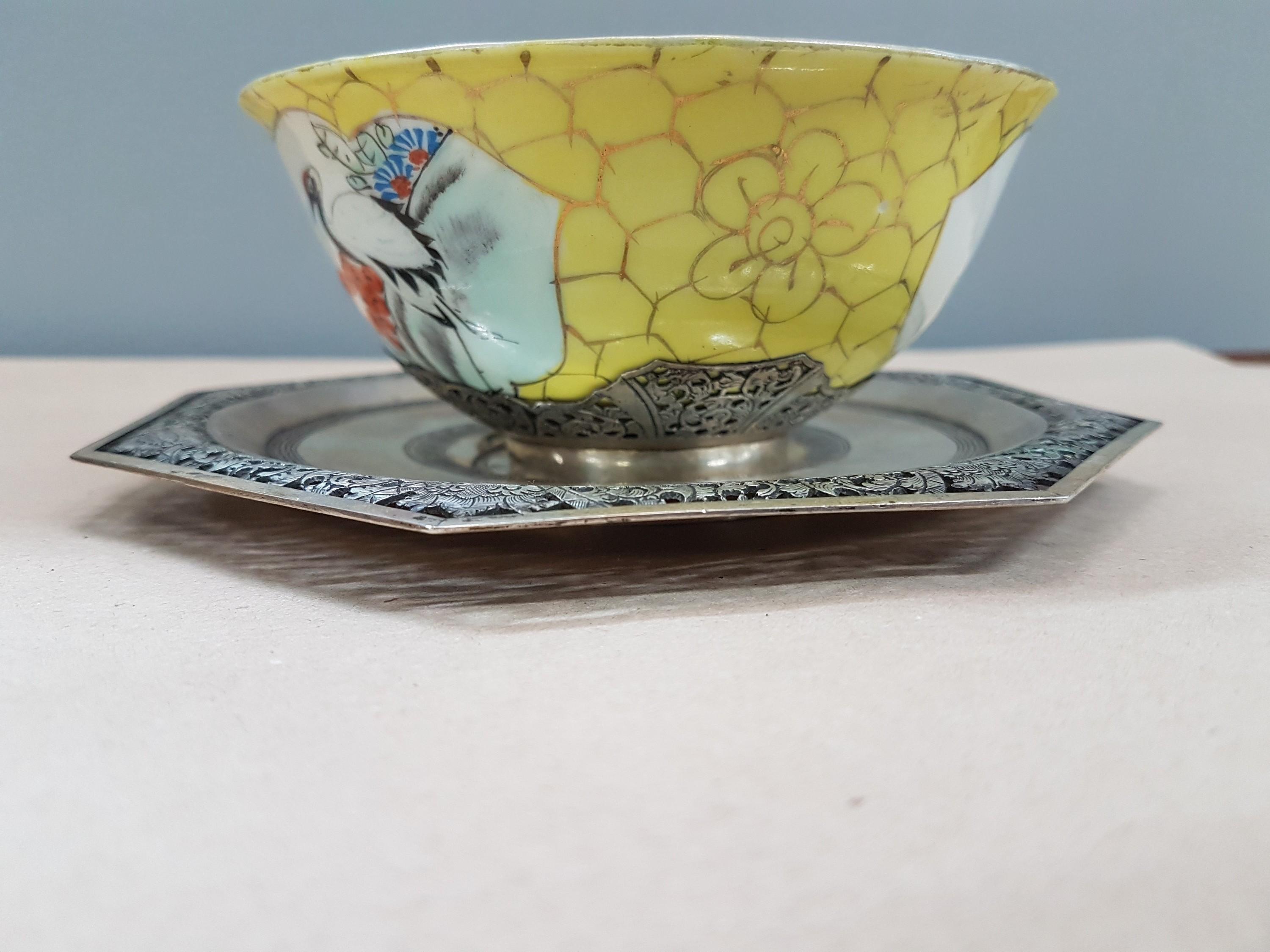 Detail b: Teetasse mit Untertasse, China, um 1900, Porzellantasse gelbgrundig, in 2 Kartuschen Blumenmalerei, Montur und Henkel sowie Untertasse Silber, teils ...
