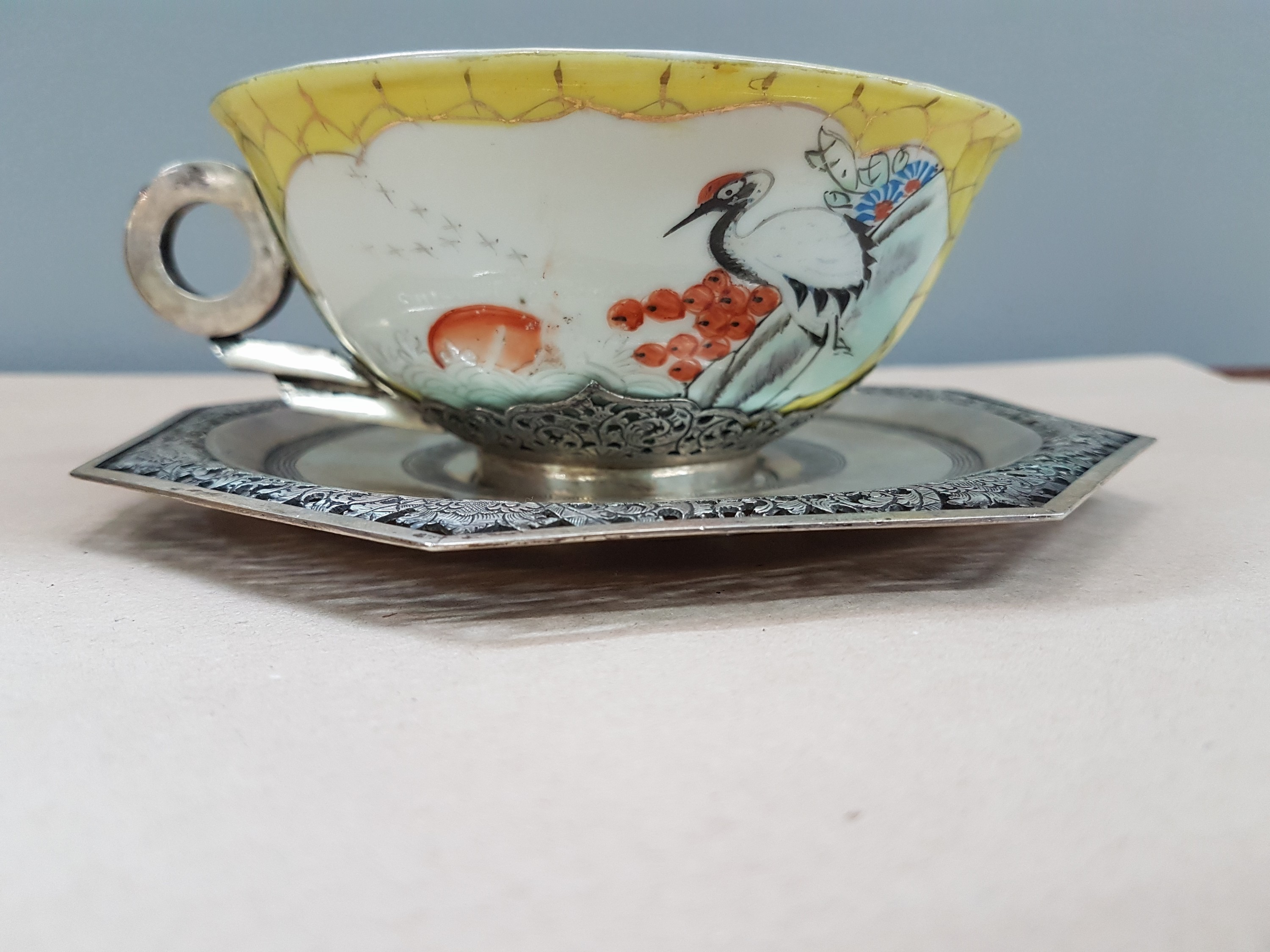 Detail c: Teetasse mit Untertasse, China, um 1900, Porzellantasse gelbgrundig, in 2 Kartuschen Blumenmalerei, Montur und Henkel sowie Untertasse Silber, teils ...