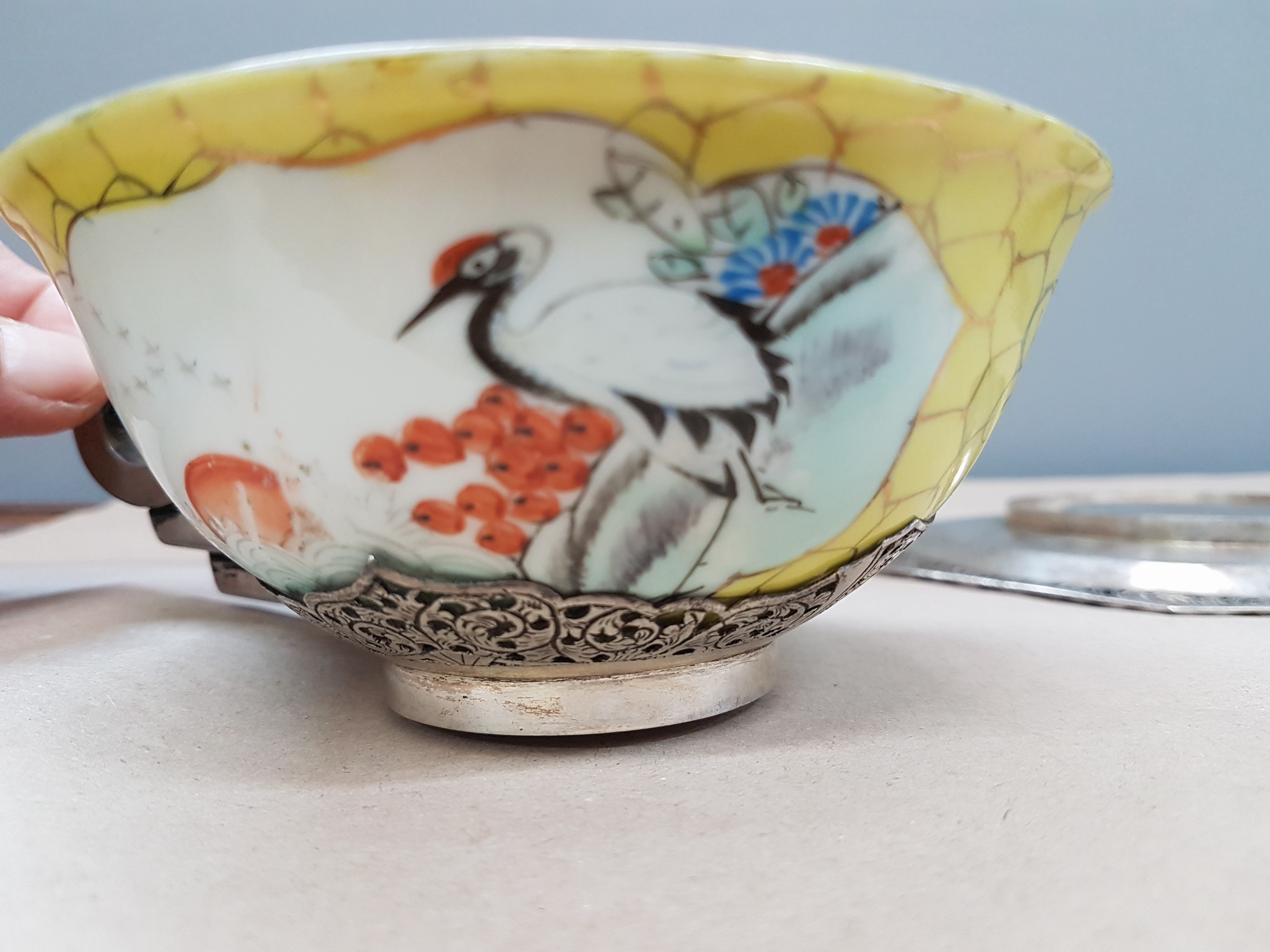 Detail g: Teetasse mit Untertasse, China, um 1900, Porzellantasse gelbgrundig, in 2 Kartuschen Blumenmalerei, Montur und Henkel sowie Untertasse Silber, teils ...