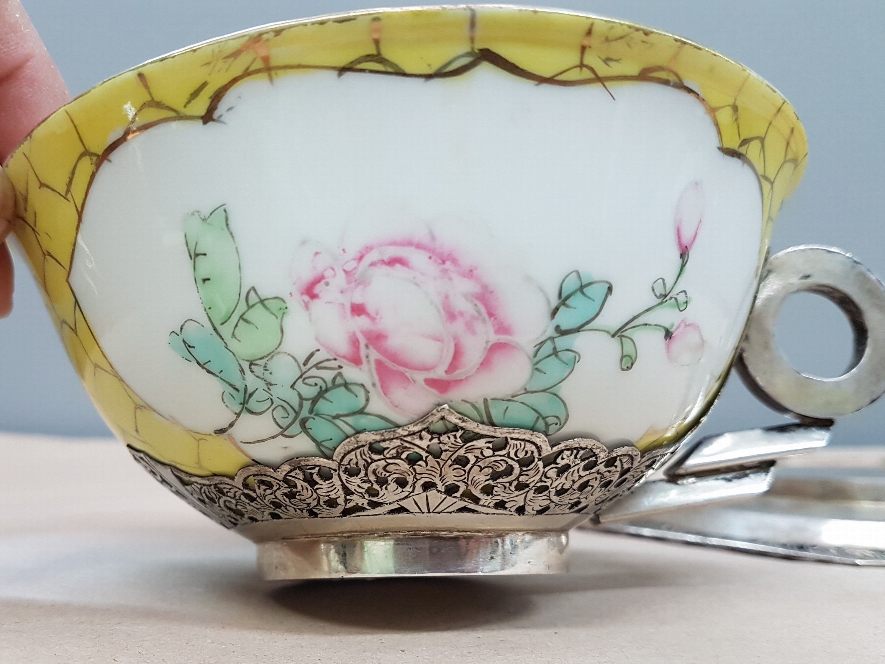 Detail h: Teetasse mit Untertasse, China, um 1900, Porzellantasse gelbgrundig, in 2 Kartuschen Blumenmalerei, Montur und Henkel sowie Untertasse Silber, teils ...