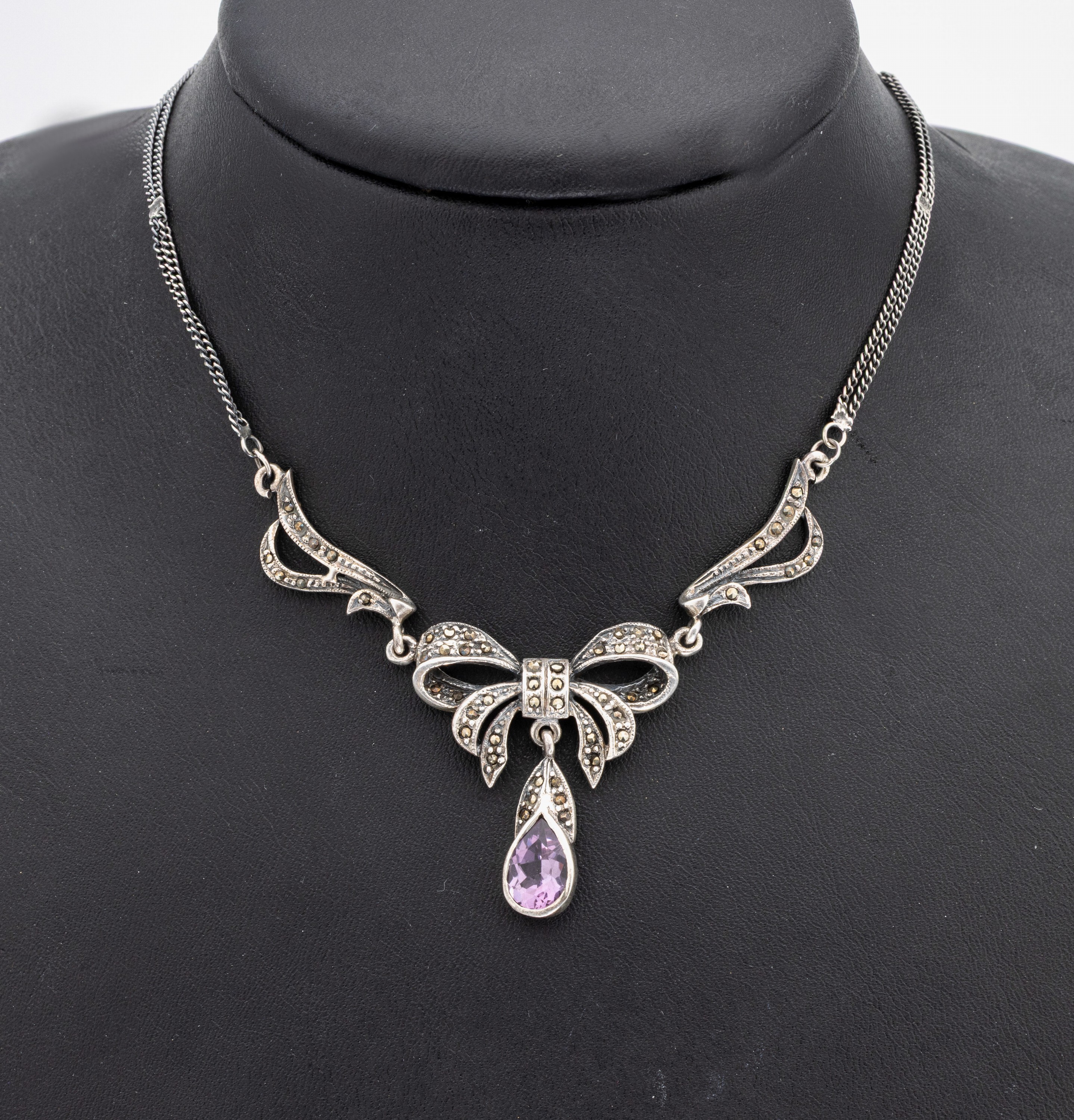 Amethyst-Markasit-Collier, um 1920/30, 925er Silber, Mittelteil schleifenförm., bewegl. Abhängung mit facett. Amethysttropfen,Markasitbes., L. ca. ...