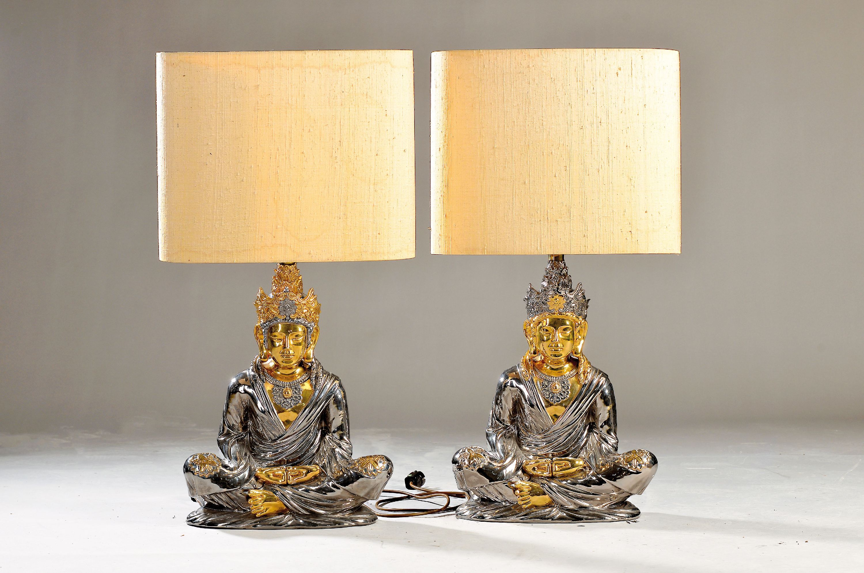 Paar Skulpturenlampen mit Buddhas, Italien, 1970er-Jahre, Keramikkorpus, glänzend silber- und goldfarben lackiert, Buddhas im Meditationssitz, je ...