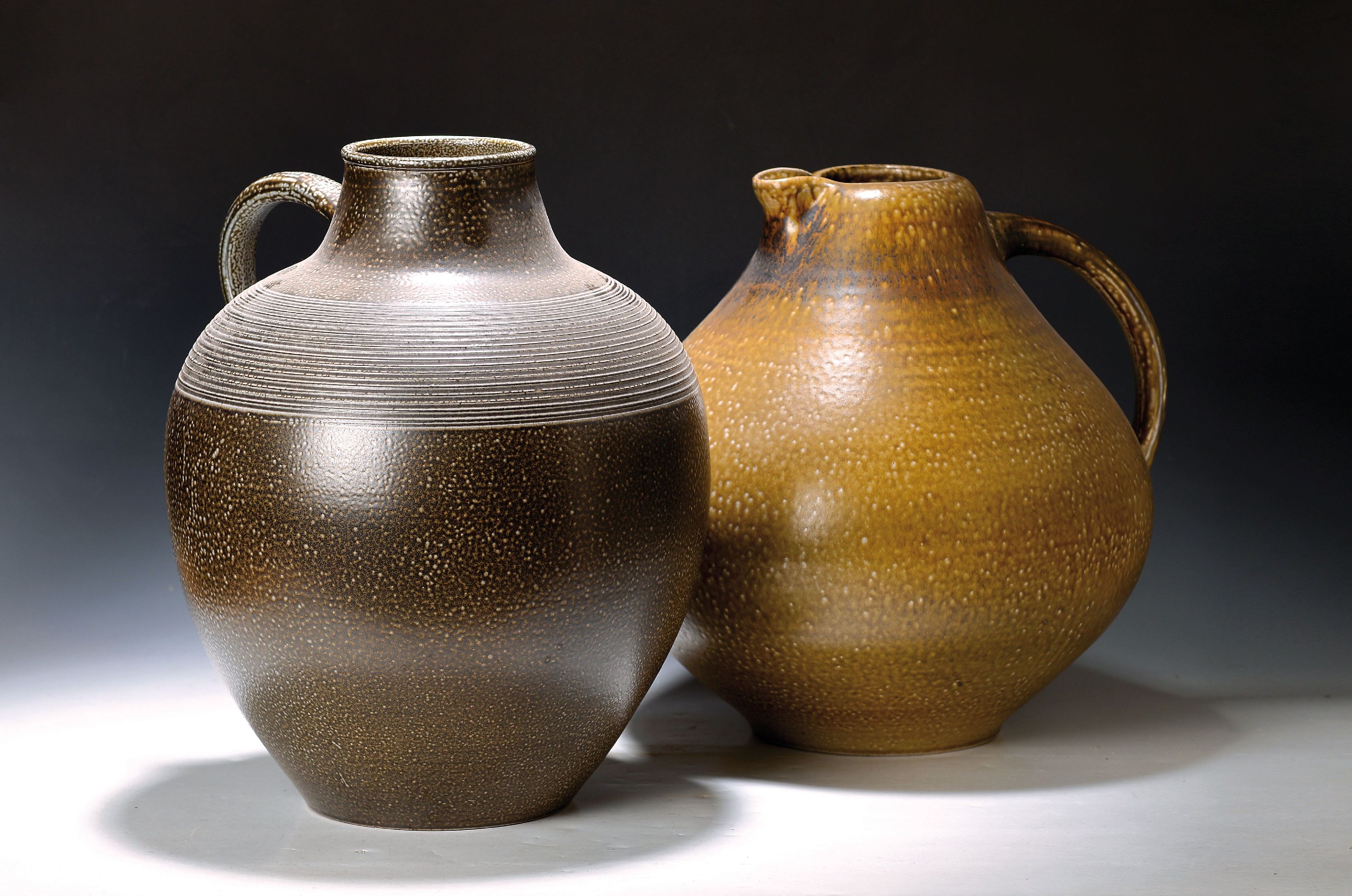 2 große Henkelkrüge, Elfriede Balzar-Kopp (1904-1983) und Wim Mühlendyck (1905-1986), Steingut, braun bzw. ockerfarben glasiert, je am Boden ...