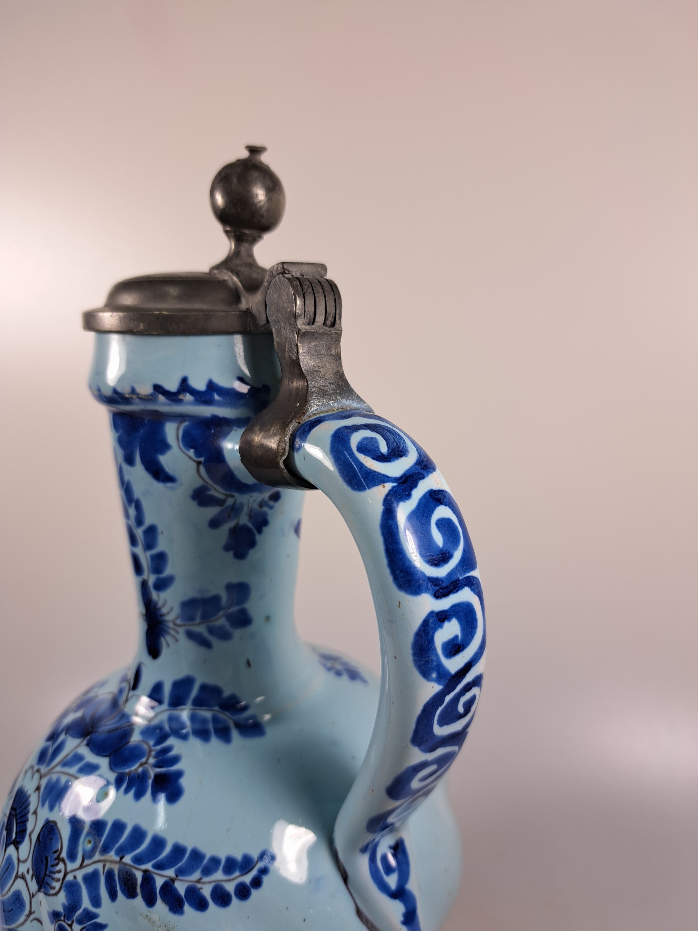 Detail e: Enghalskrug, Hanau, um 1740, Fayence, Drehermarke E, hellblauer, Grund mit blauer Blumenbemalung, rest., Zinndeckel, H. ca.31 cm