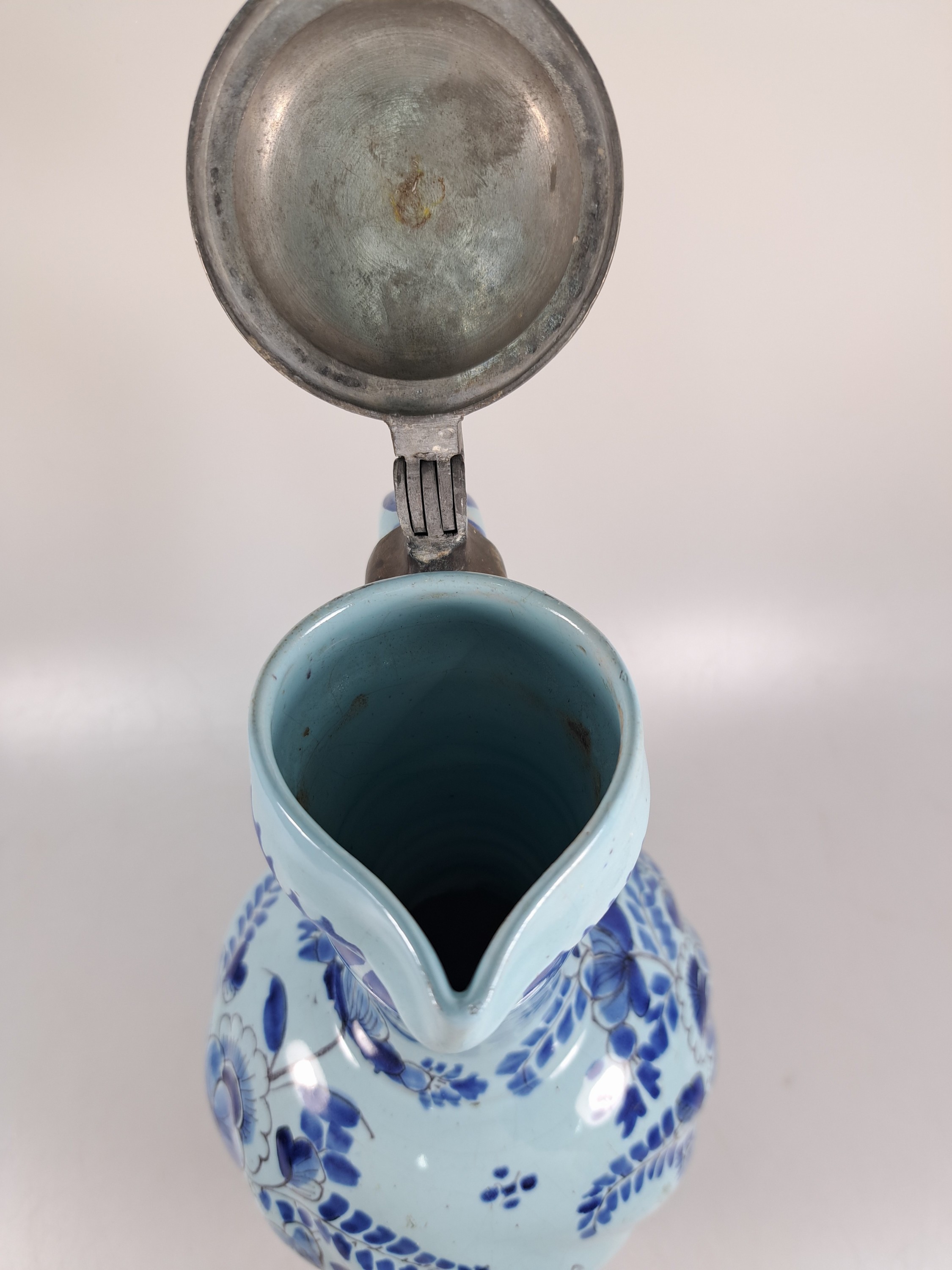 Detail g: Enghalskrug, Hanau, um 1740, Fayence, Drehermarke E, hellblauer, Grund mit blauer Blumenbemalung, rest., Zinndeckel, H. ca.31 cm