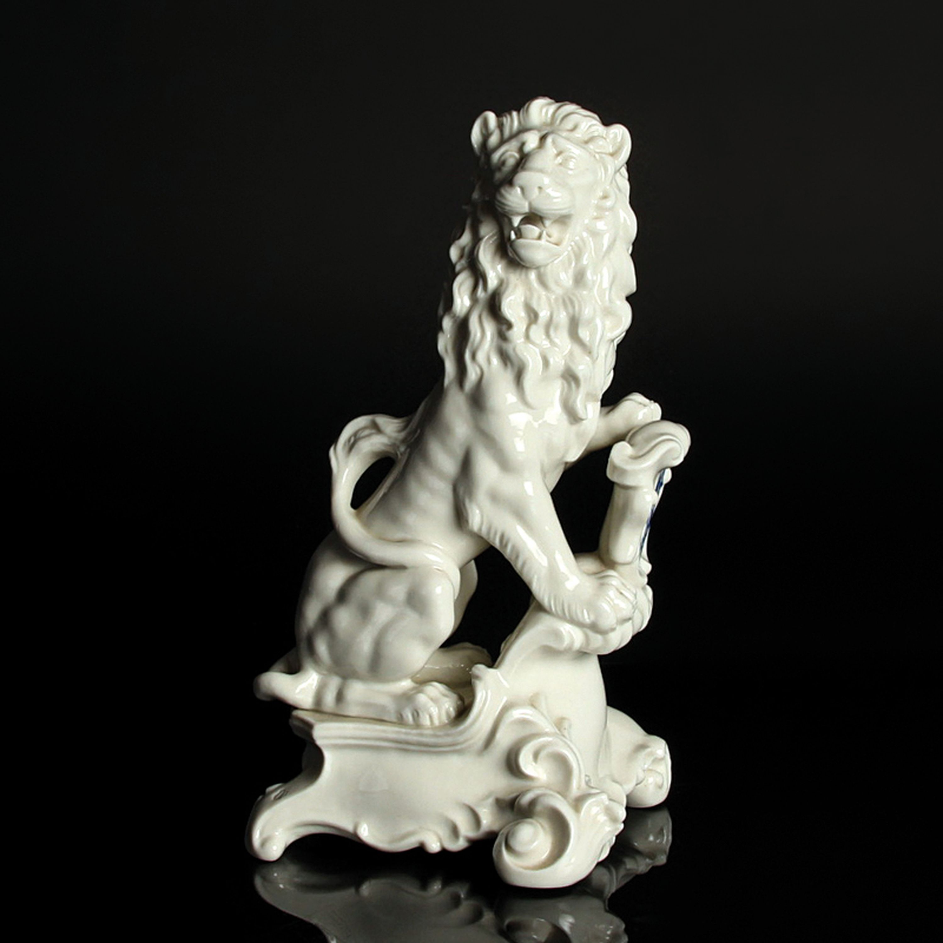Porzellanfigur bayerischer Löwe, Nymphenburg, 20.Jh., Entw. J. Wackerle, Weißporzellan, blau staffiertes Wappenschild, am Boden signiert, H. 23 cm