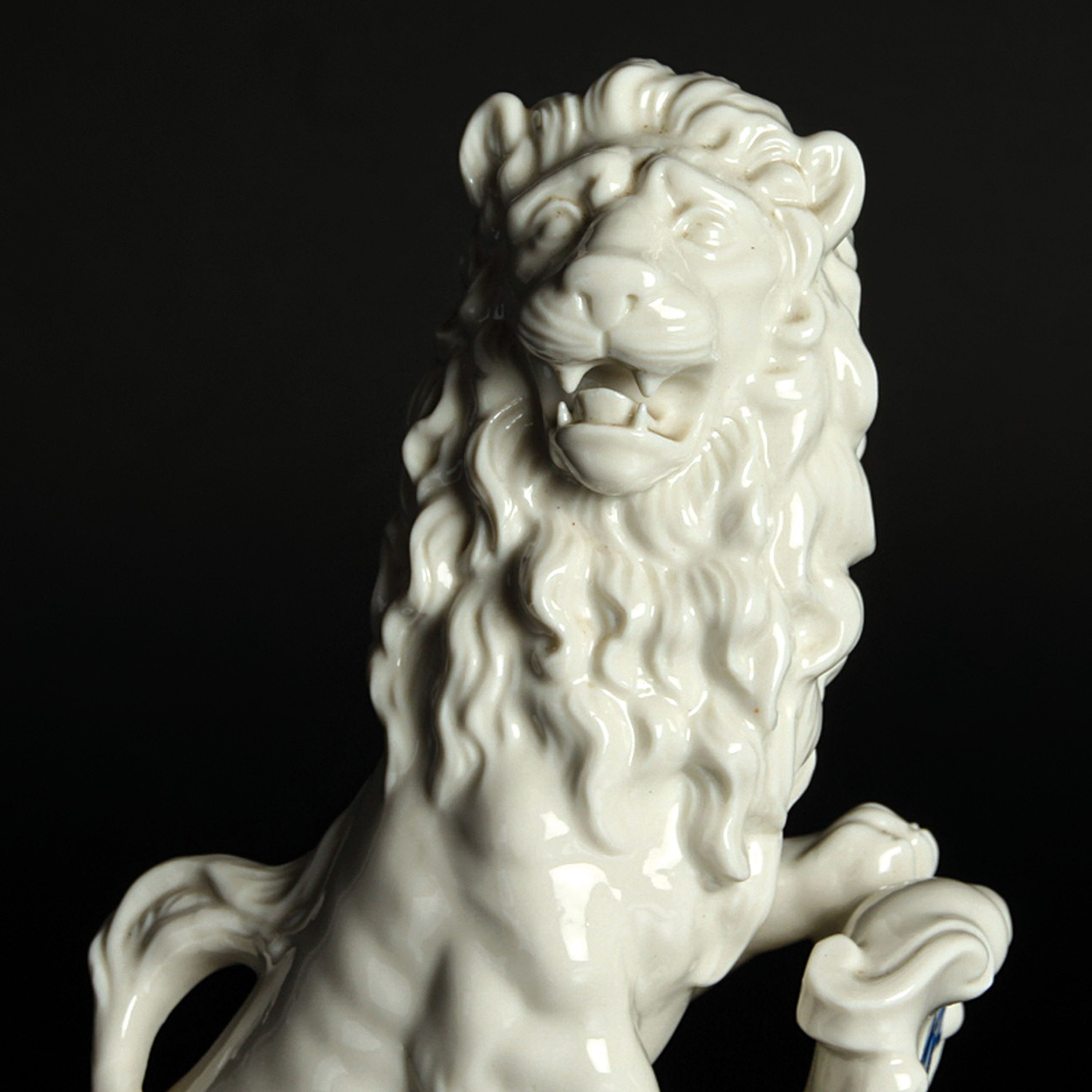 Detail a: Porzellanfigur bayerischer Löwe, Nymphenburg, 20.Jh., Entw. J. Wackerle, Weißporzellan, blau staffiertes Wappenschild, am Boden signiert, H. 23 cm