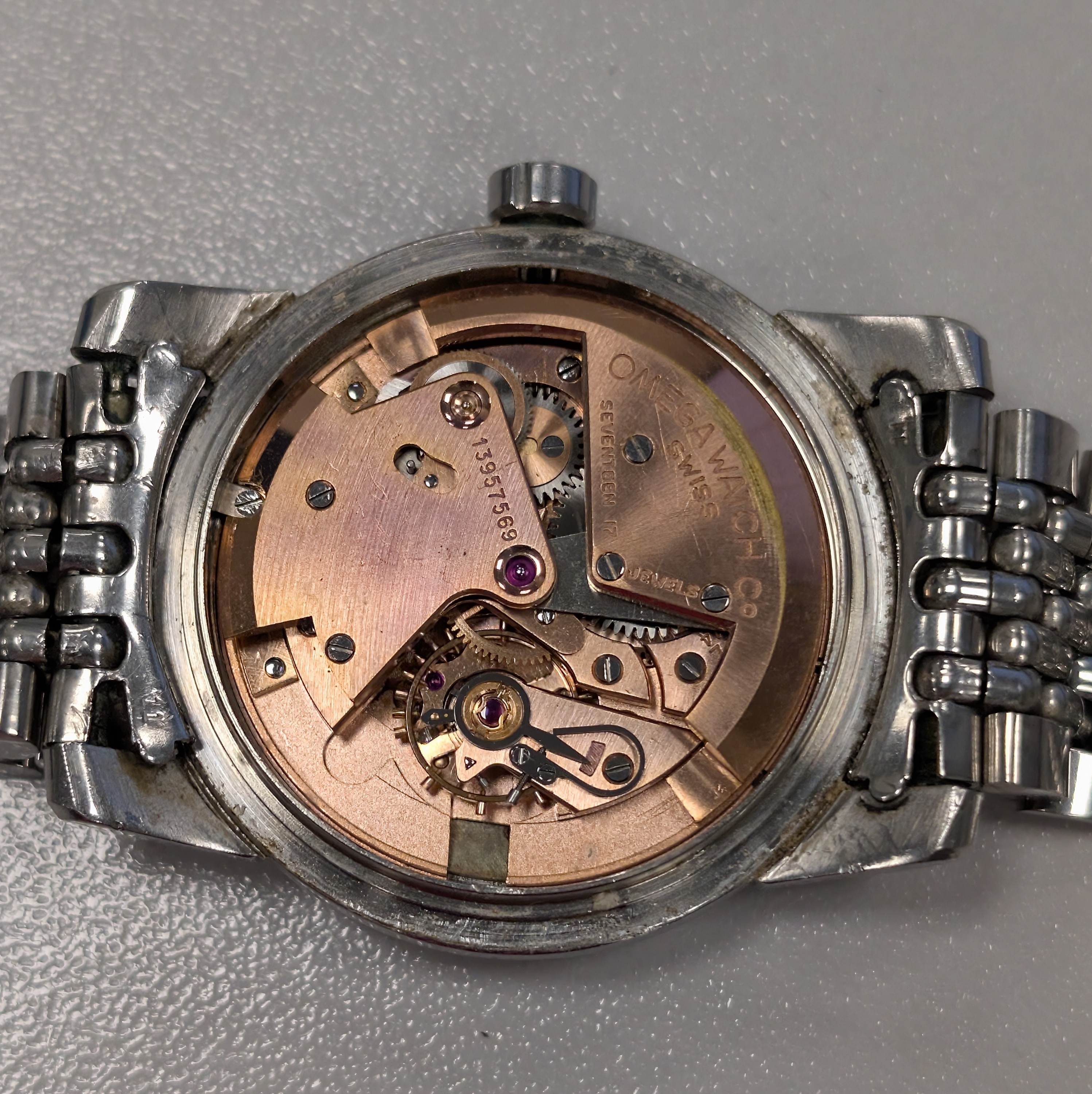 Detail e: OMEGA Seamaster Herrenarmbanduhr mit Hammerautomatik Referenz 2766-2, Schweiz um 1954, Boden aufgedr., orig. Stahlband m. Faltschl., silb. Zifferbl. ...