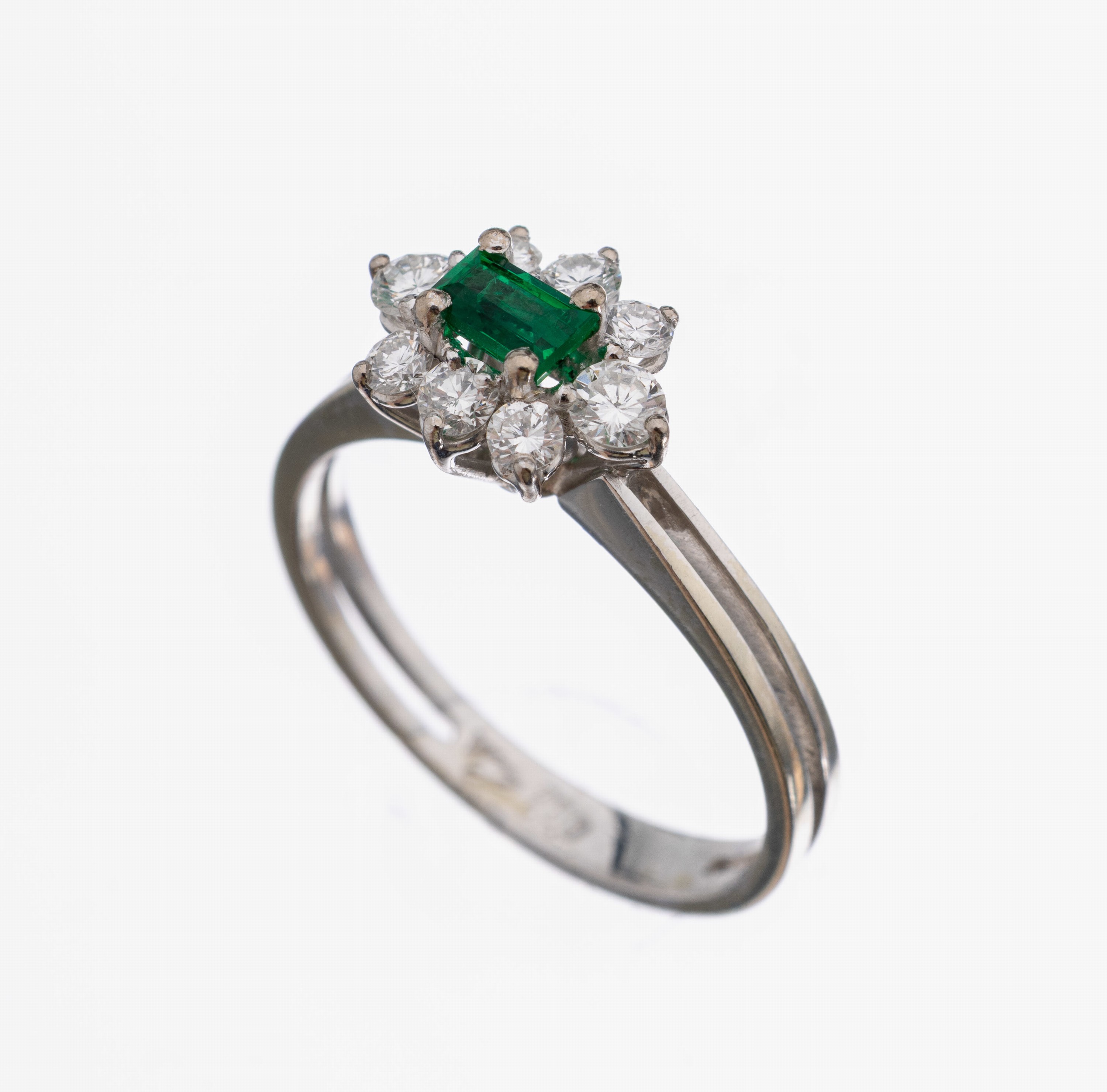 18 kt Gold Smaragd-Brillant-Ring, WG 750/000, mittig facett. Smaragdbaguette ca. 0.10 ct, umgeben von 8 Brillanten zus. ca. 0.36 ct feines Weiß/si, ...