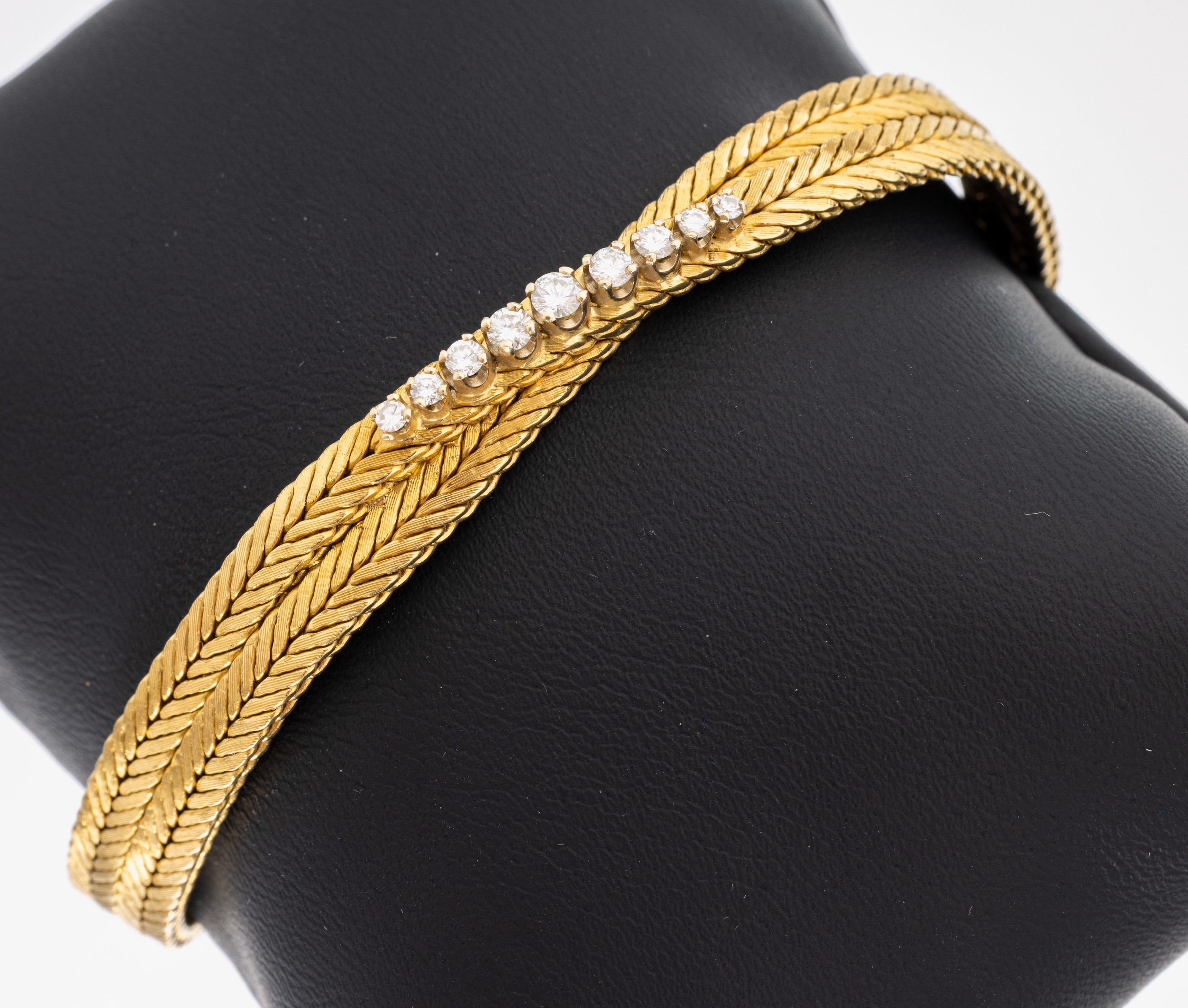 18 kt Gold Brillant-Armband, GG 750/000, Flechtoptik, Mittelteil mit 9 in WG gefassten Brillanten zus. ca. 0.32 ct Weiß/vs-si, L. ca 19 cm, ...