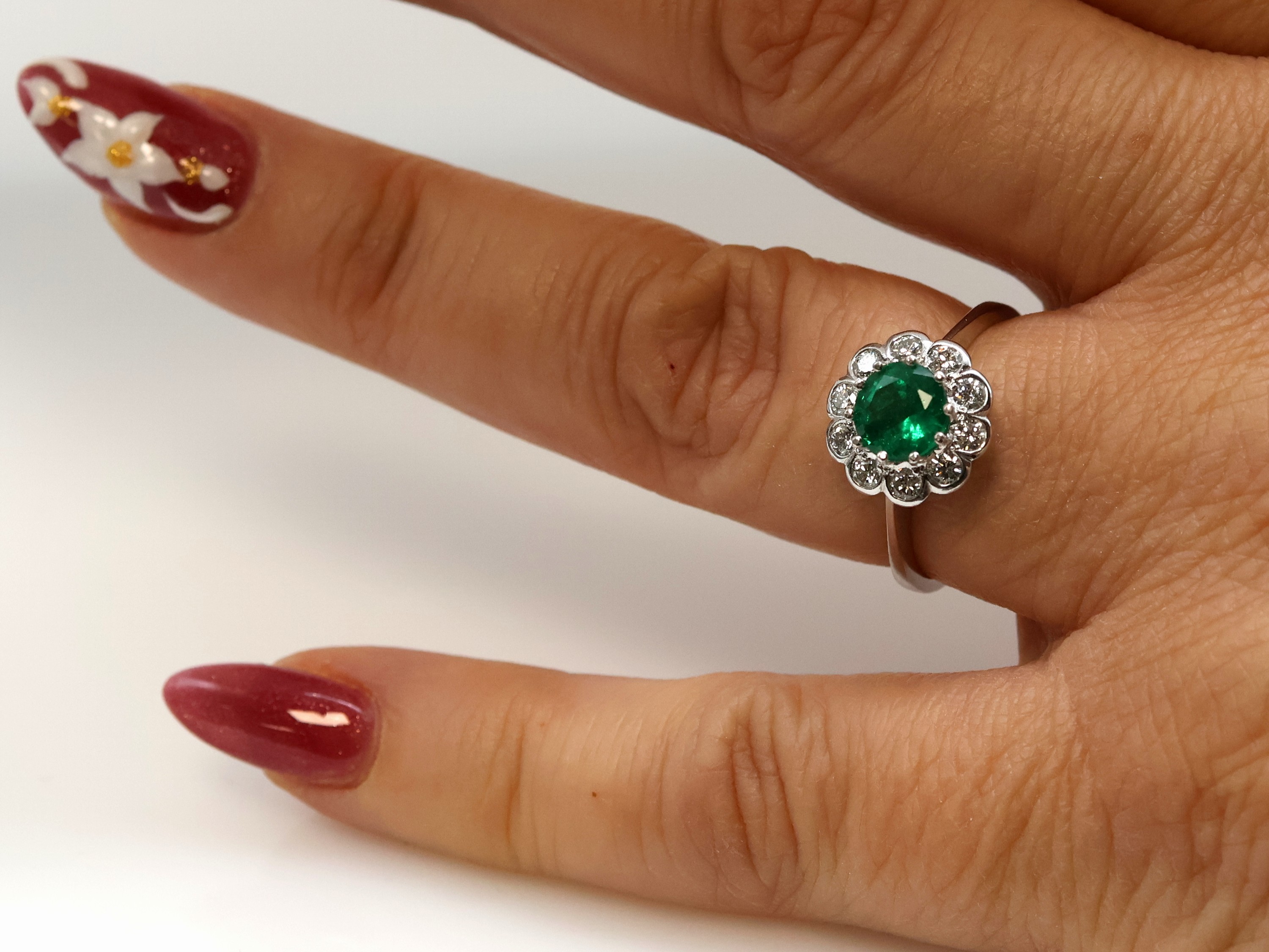 Detail b: 14 kt Gold Smaragd-Brillant-Ring, WG 585/000, mittig ein rundfacett. Smaragd ca. 1.25 ct von feiner Farbe, umgeben von 10 Brillanten zus. ca. 0.50 ...