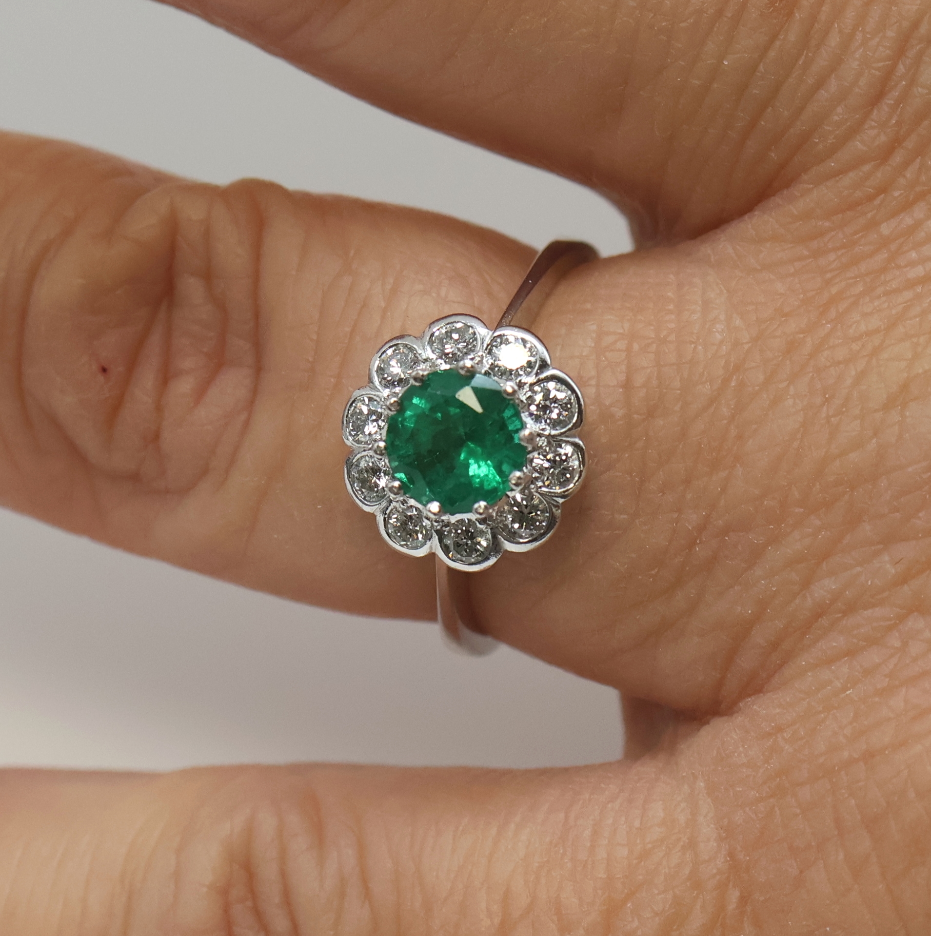 Detail c: 14 kt Gold Smaragd-Brillant-Ring, WG 585/000, mittig ein rundfacett. Smaragd ca. 1.25 ct von feiner Farbe, umgeben von 10 Brillanten zus. ca. 0.50 ...