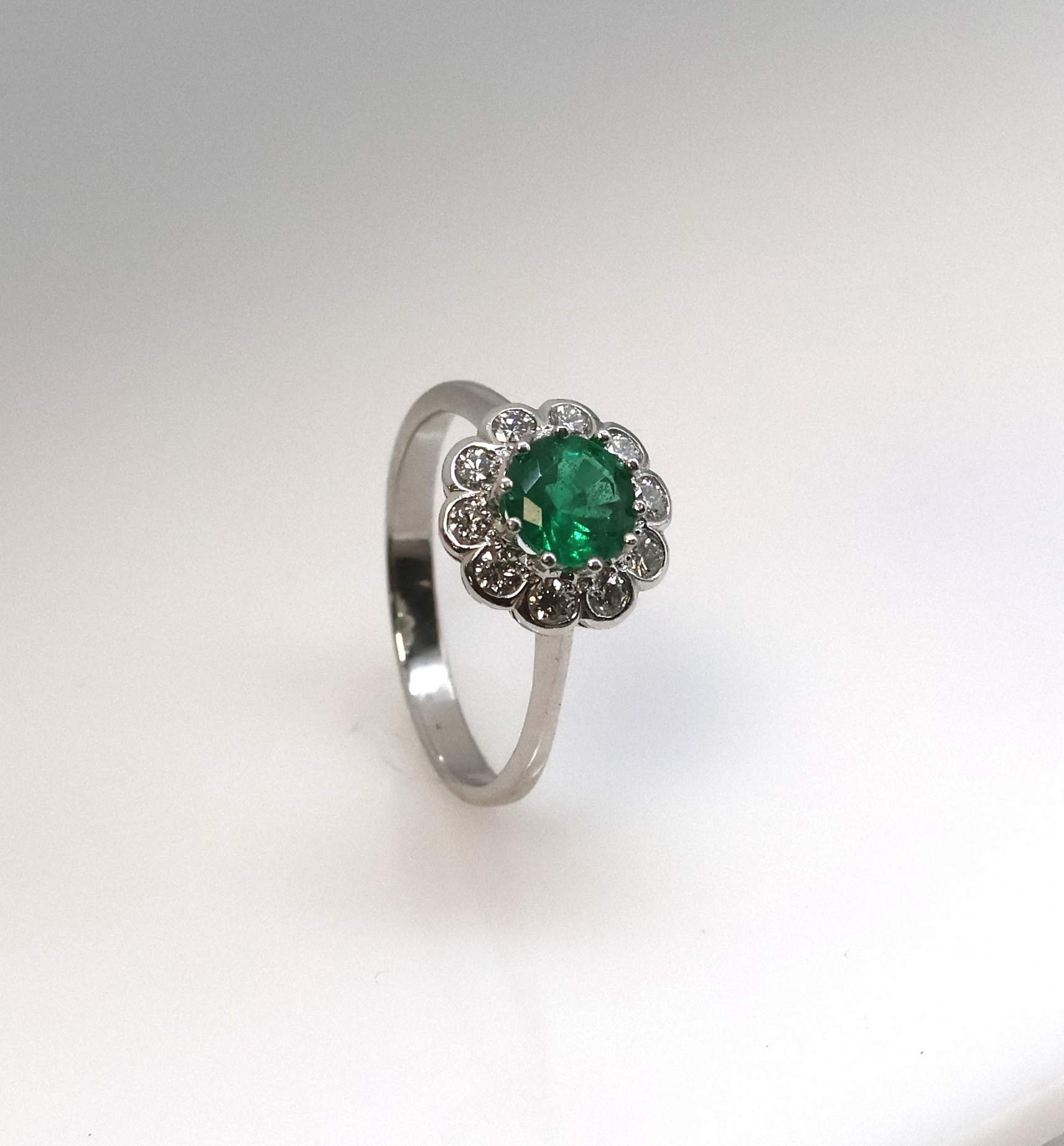 Detail d: 14 kt Gold Smaragd-Brillant-Ring, WG 585/000, mittig ein rundfacett. Smaragd ca. 1.25 ct von feiner Farbe, umgeben von 10 Brillanten zus. ca. 0.50 ...