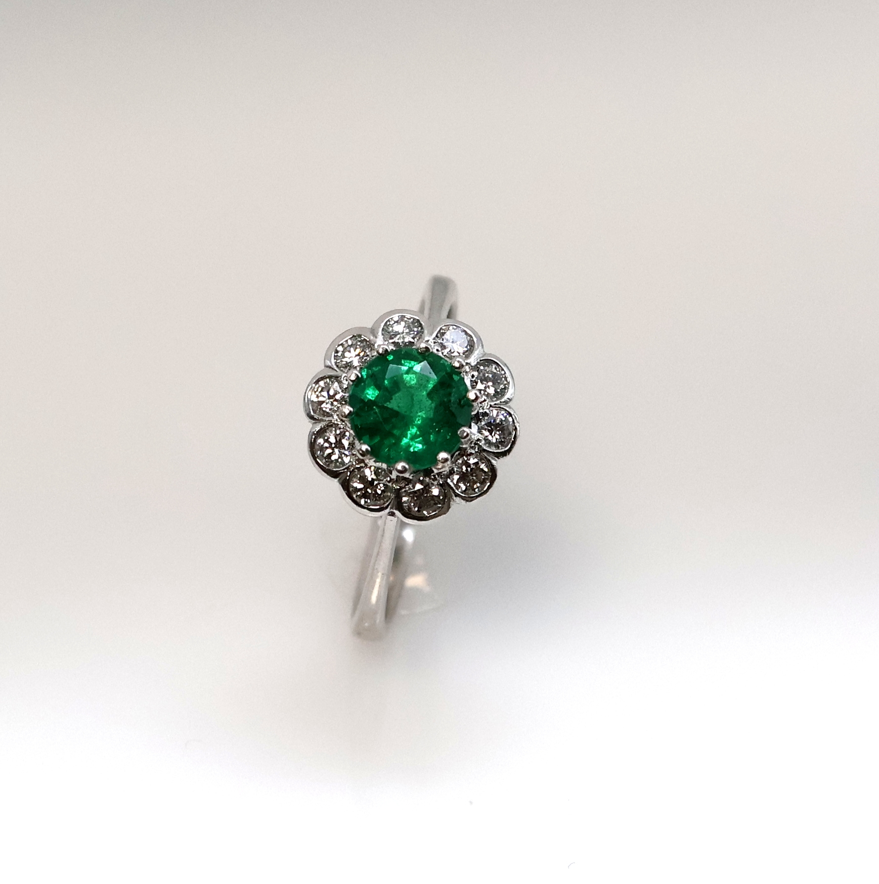 Detail e: 14 kt Gold Smaragd-Brillant-Ring, WG 585/000, mittig ein rundfacett. Smaragd ca. 1.25 ct von feiner Farbe, umgeben von 10 Brillanten zus. ca. 0.50 ...