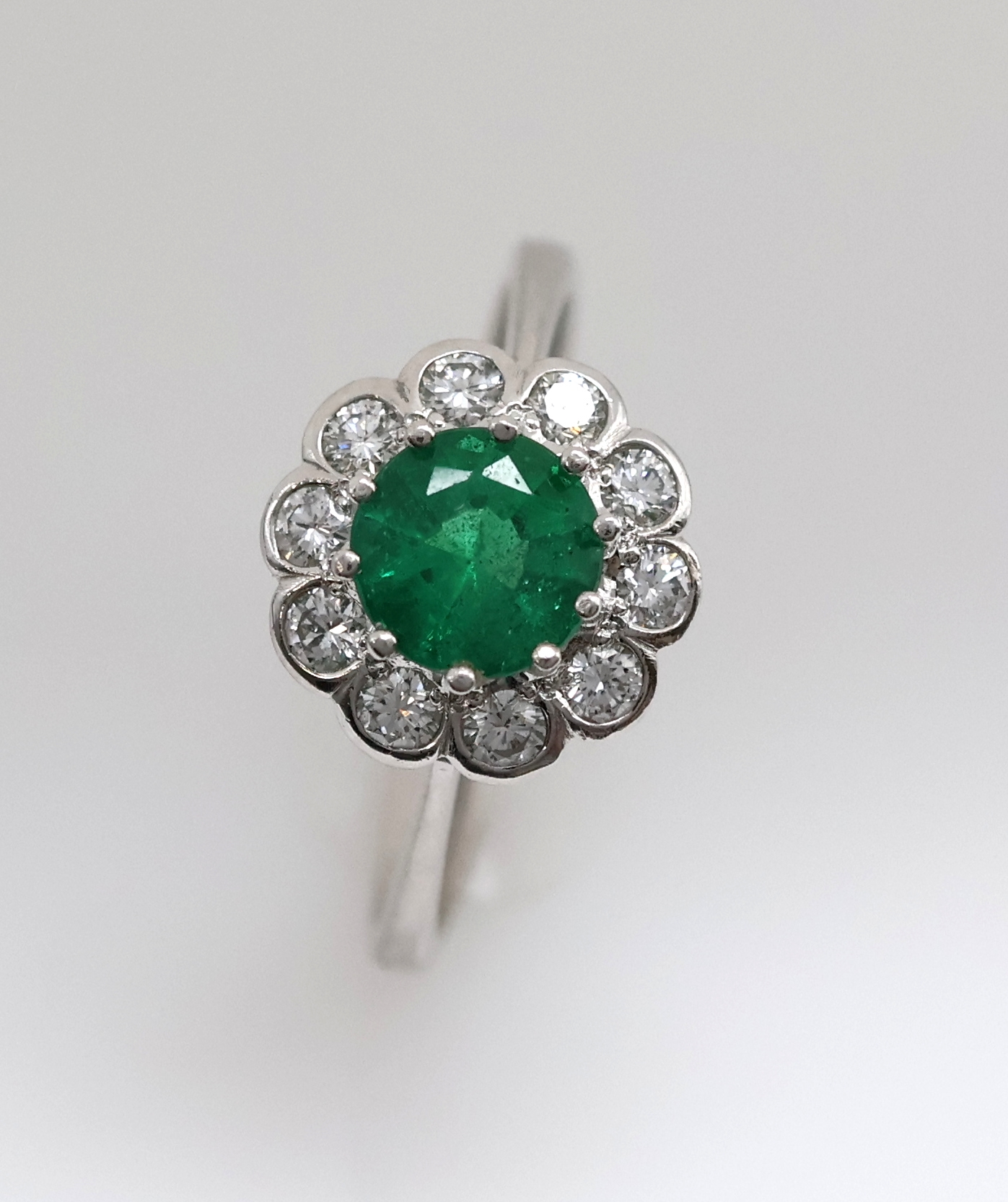 Detail h: 14 kt Gold Smaragd-Brillant-Ring, WG 585/000, mittig ein rundfacett. Smaragd ca. 1.25 ct von feiner Farbe, umgeben von 10 Brillanten zus. ca. 0.50 ...