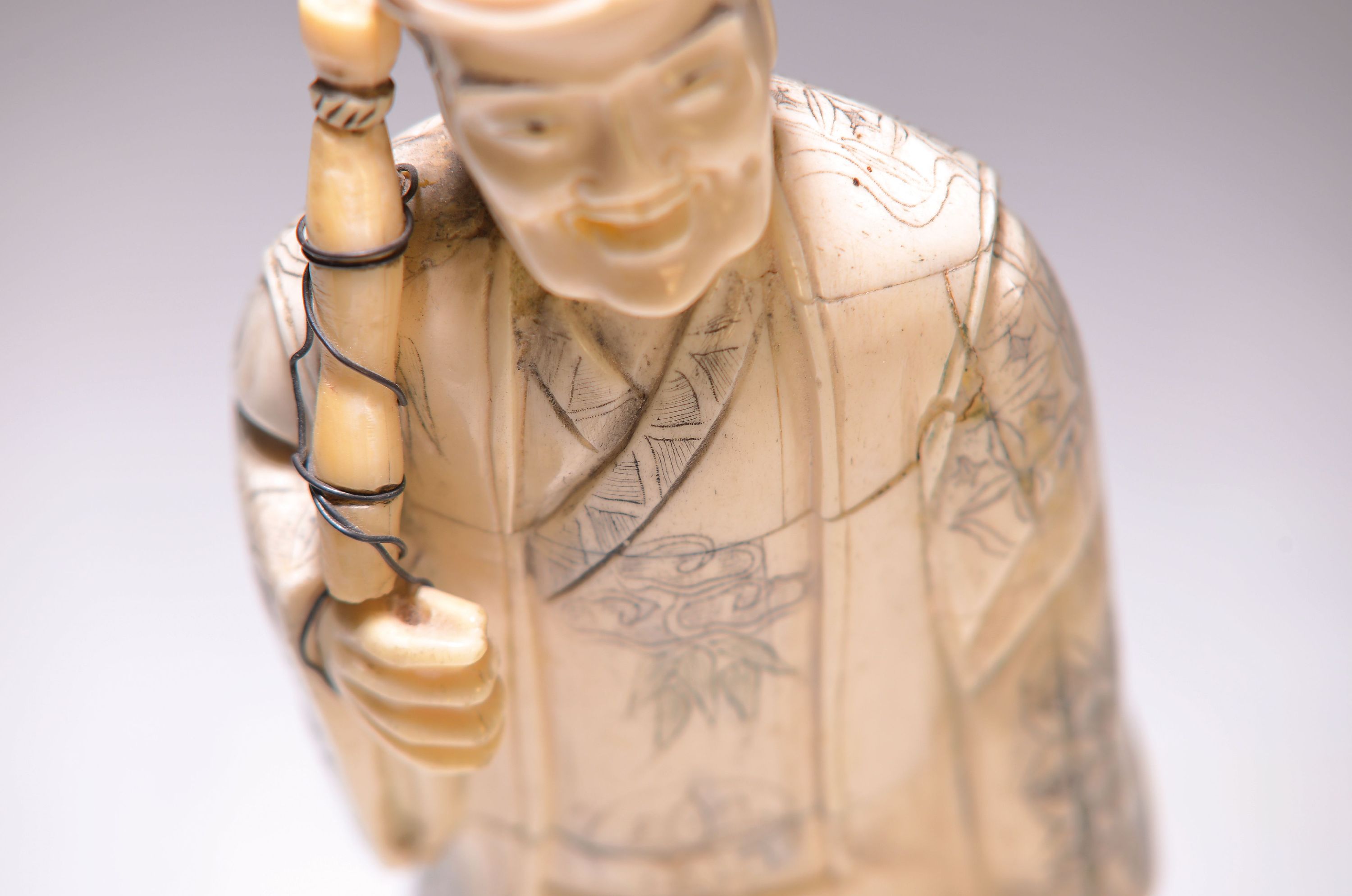 Detail a: Beinskulptur eines Fischers, China, 20.Jh., Holzkorpus mit Beinplättchen, stehender Fischer, Ritzdekor geschwärzt, Angel fragmentarisch, H. 27 cm