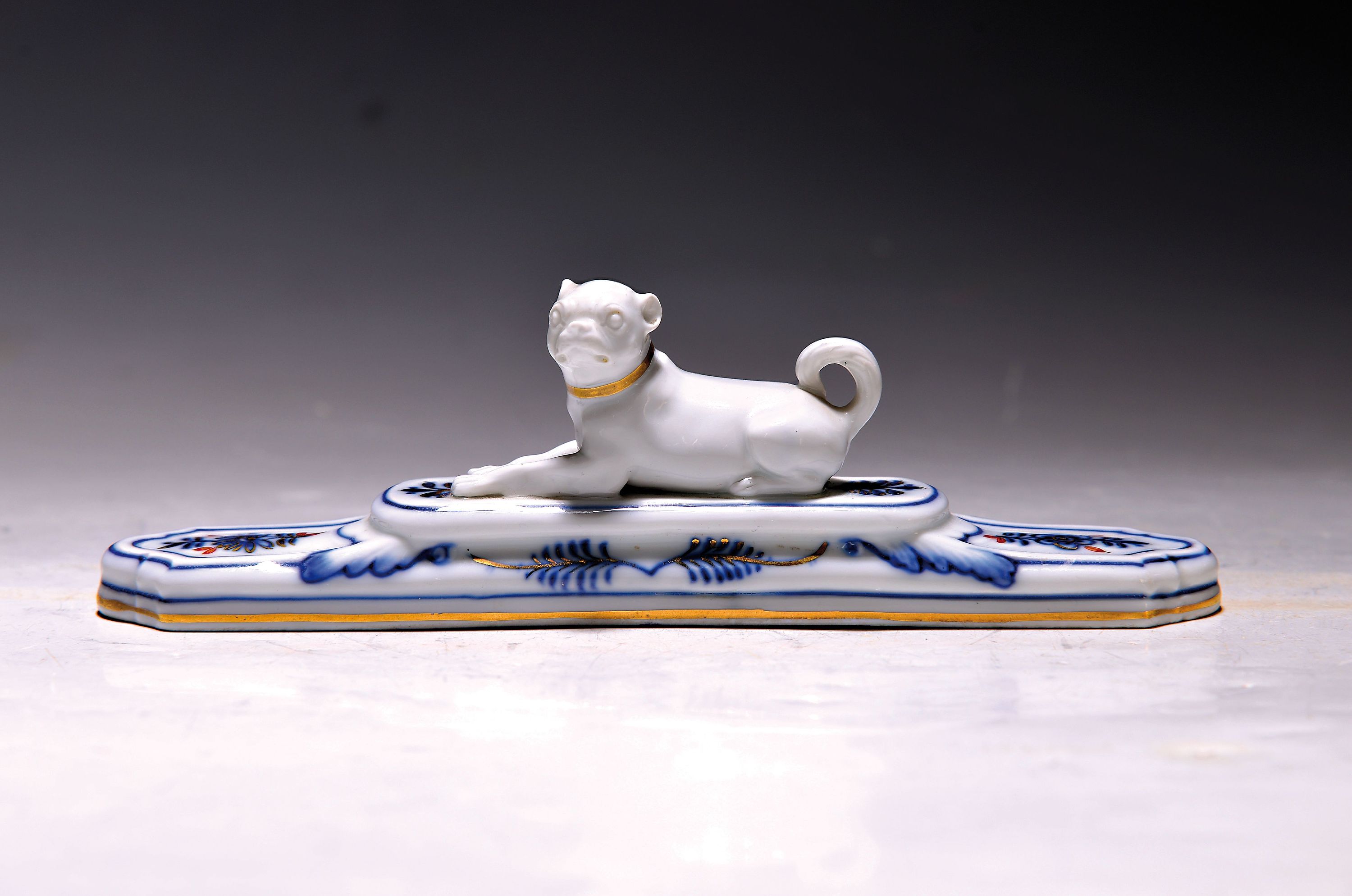 Briefbeschwerer mit Mops, Meissen, Knaufzeit , Porzellan, unterglasurblauer Dekor, Gold- und Rotstaffage, L. 19 cm