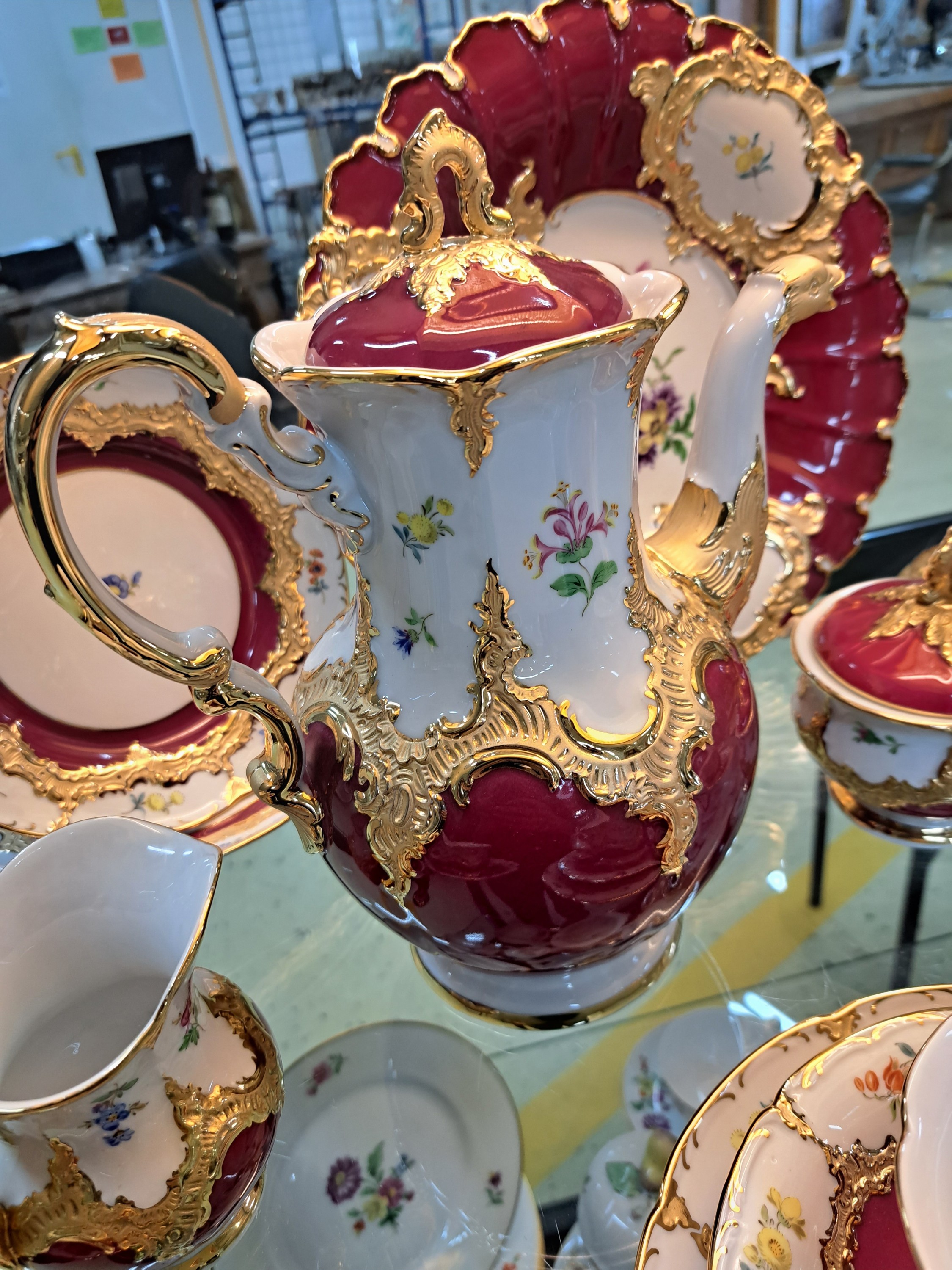 Detail e: Kernstück und drei Gedecke, Meissen, um 1890, 1. Wahl, B-Form, partiell dunkelrot glasiert, bunt bemalt mit gestreuten Blumen, Relief matt- und ...