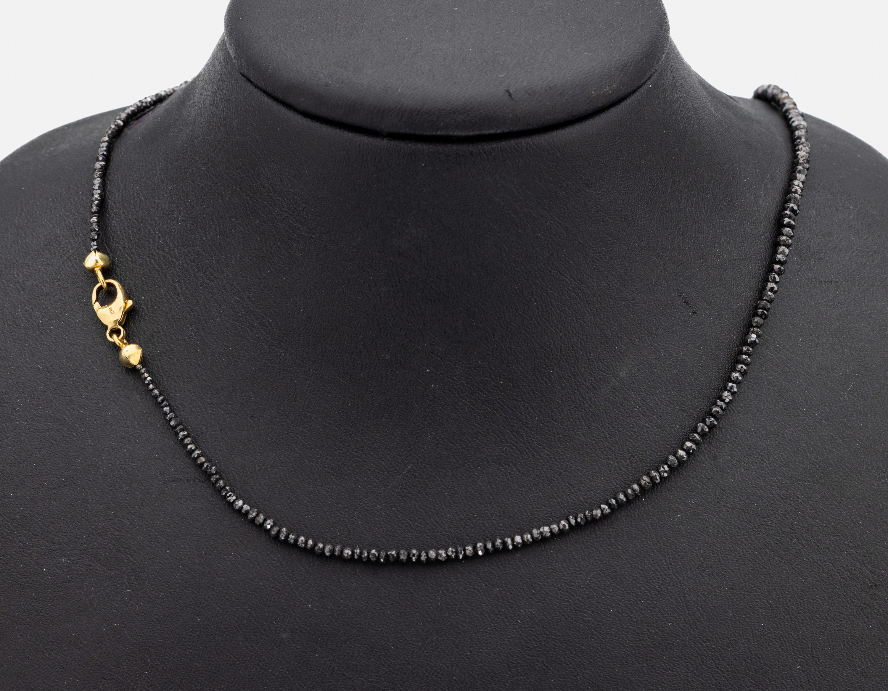 Diamant-Collier mit 14 kt Gold Schließe, GG585/000, facett. schwarze Diamanten (beh.) im Verlauf, L. ca. 45 cm, Karabinerschließe