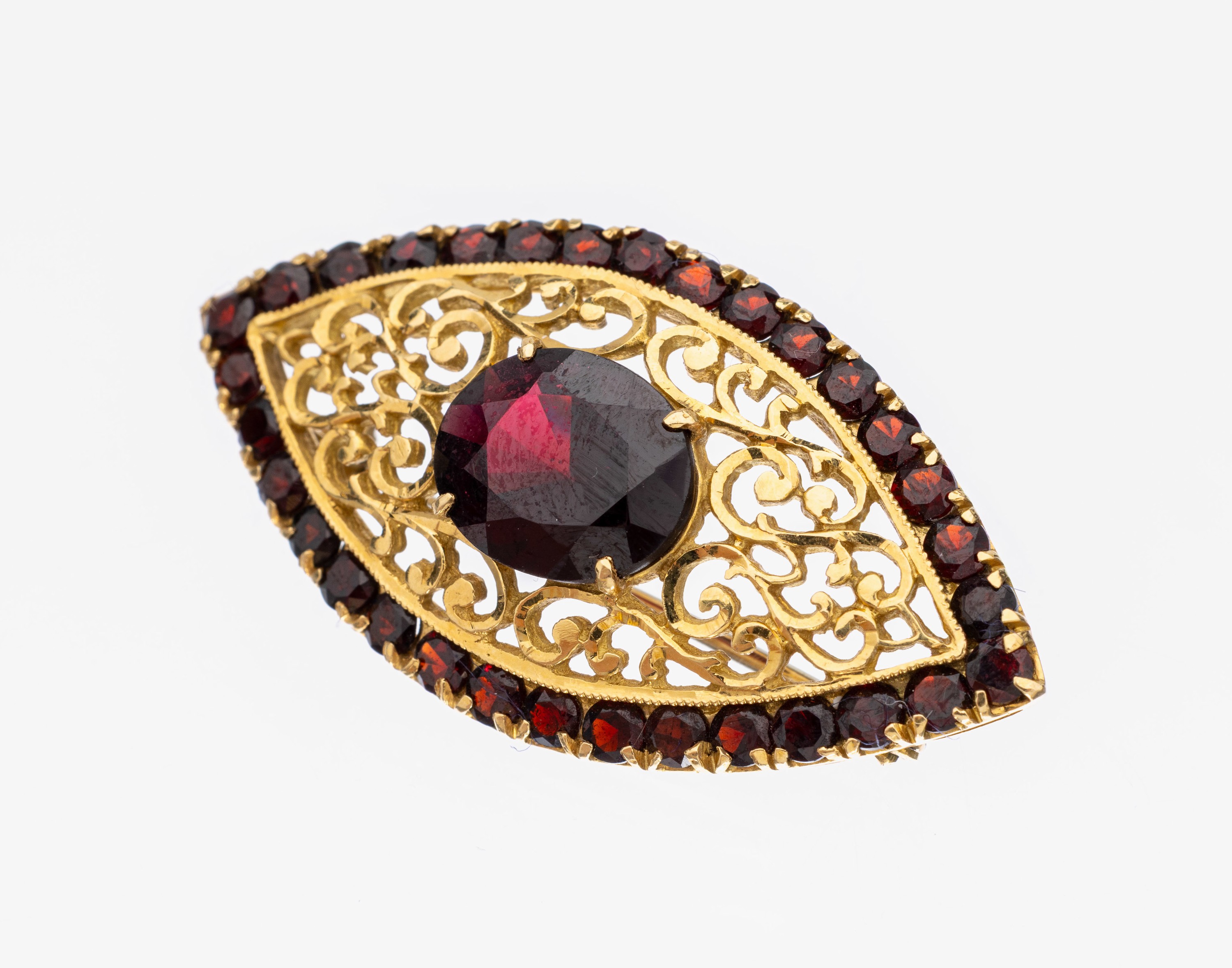 18 kt Gold Granat-Brosche, GG 750/000, qualitätvolle Verarbeitung, navetteförmig, durchbrochen gearbeitet mit Rocaillen, mittig gr. erhaben ...