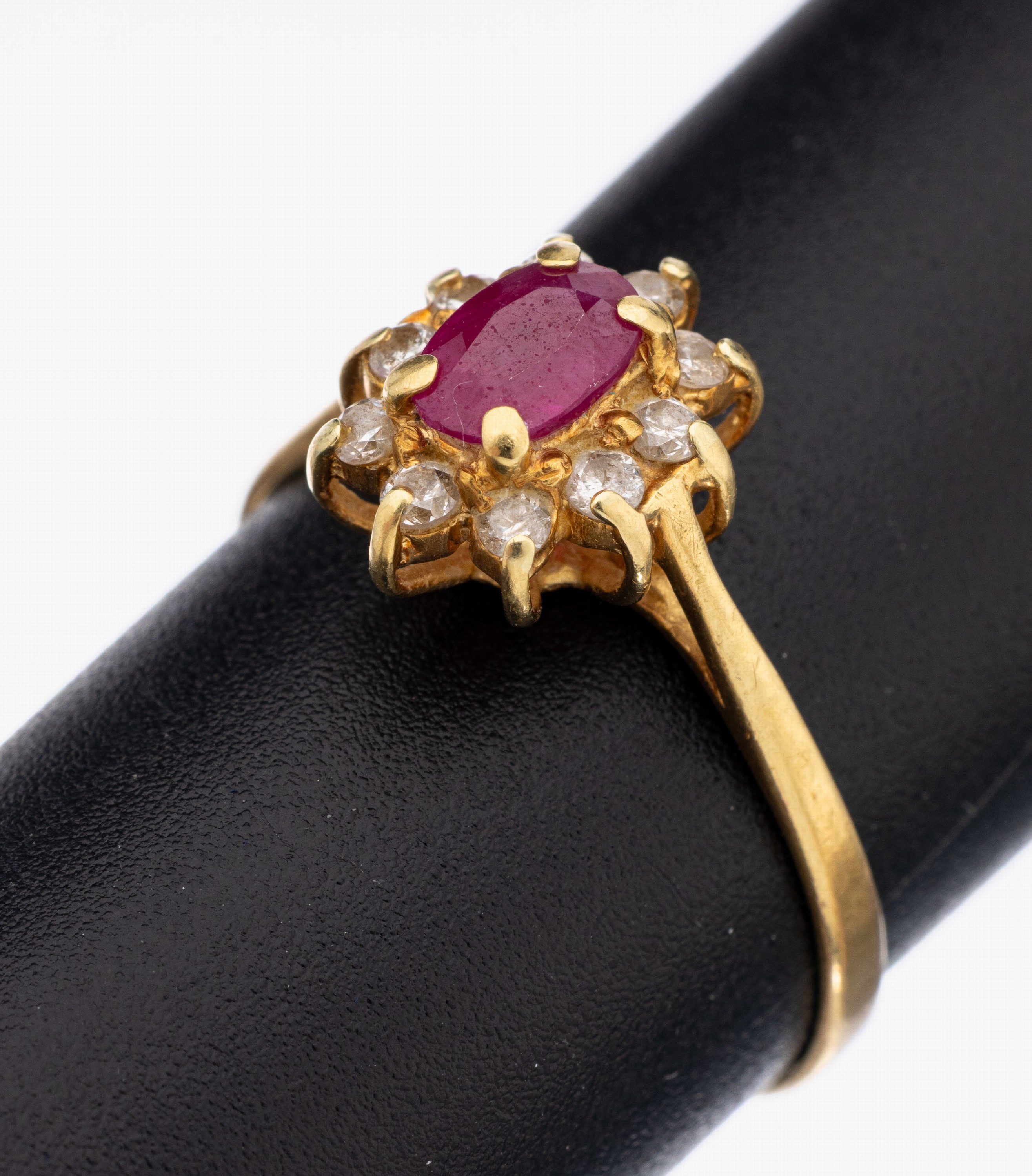 18 kt Gold Rubin-Brillant-Ring, GG 750/000,mittig erhaben gefasster rundfacett. Rubin ca.0.60 ct (grav.), 10 Brillanten zus. ca. 0.25 ct (grav.) ...