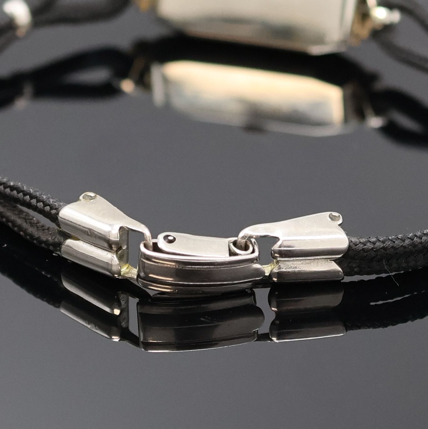 Detail b: Doxa Art-Deco Damenarmbanduhr Schweiz um 1935, Handaufzug, Platingeh. m. Diamantbesatz,feine Millegriffverz., Scharnierboden, Stoffband, fleck. silb. ...