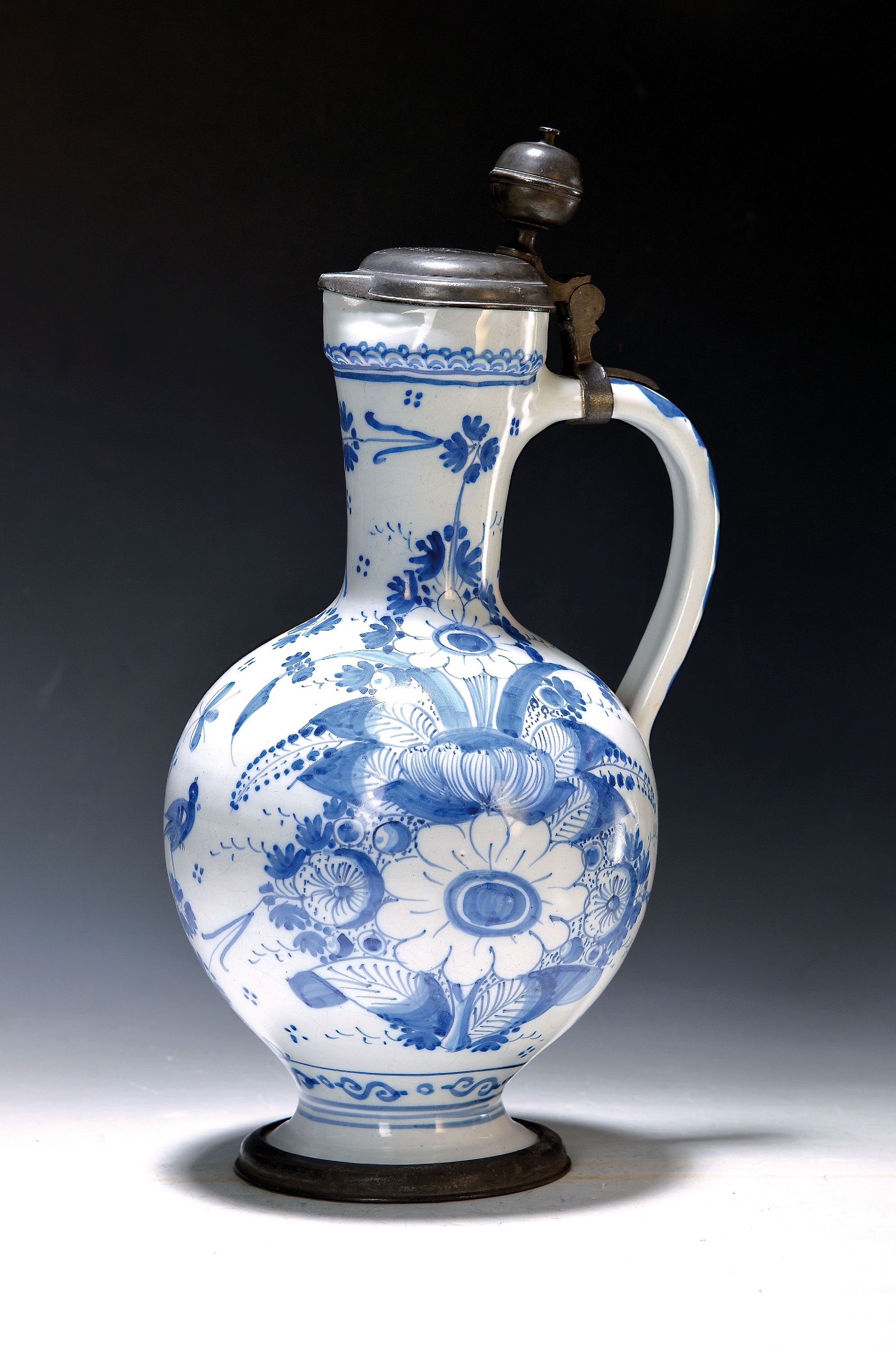 Großer Enghalskrug, 18. Jh., Fayence, heller Grund mit üppigem blauem Blumendekor, Zinndeckel bez. IW 1710, H. 38 cm