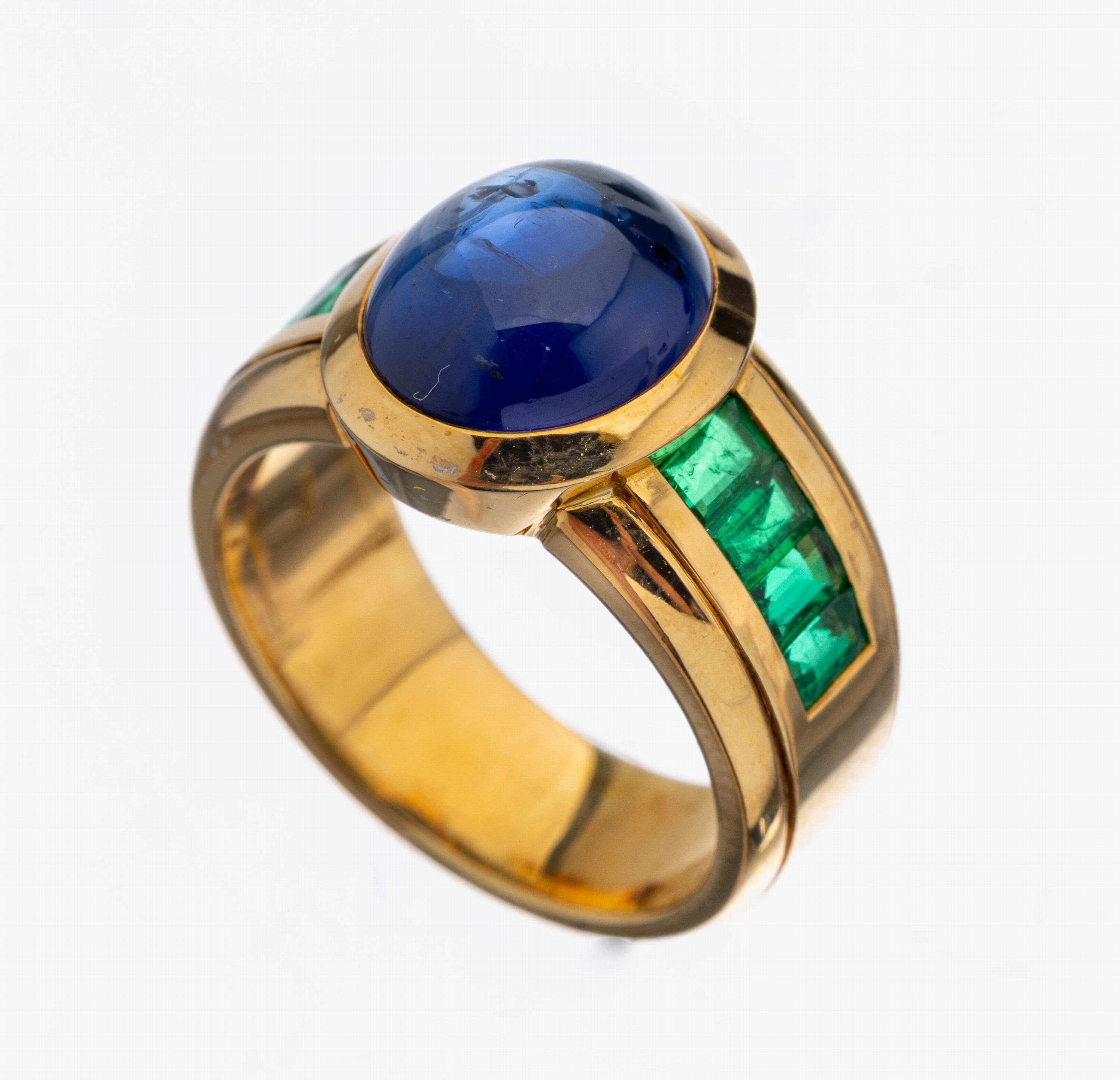 18 kt Gold Saphir-Smaragd-Ring, GG 750/000,Saphir-Cabochon ca. 6.80 ct, 8 Smaragd- Baguettes zus. ca. 0.86 ct, ca. 12.5 g, RW 55