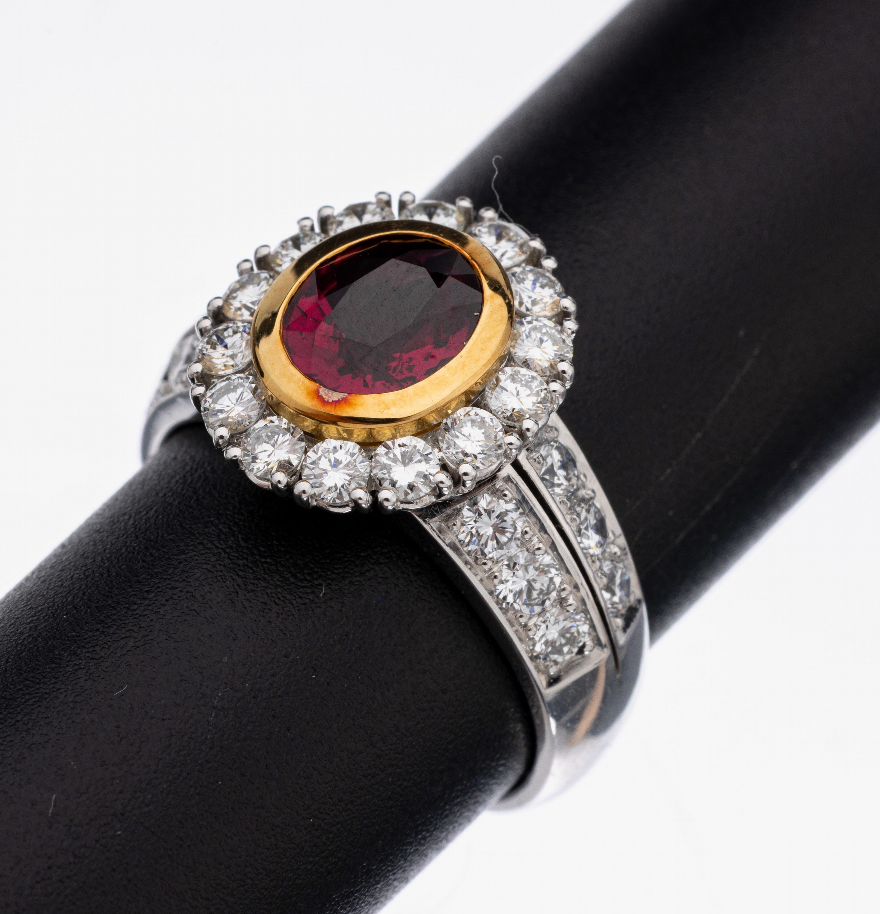 18 kt Gold Rubin-Brillant-Ring, WG/GG 750/000, in GG gefasster ovalfacett. Rubin ca. 1.52 ct, 26 Brillanten zus. ca. 1.26 ct feines ...