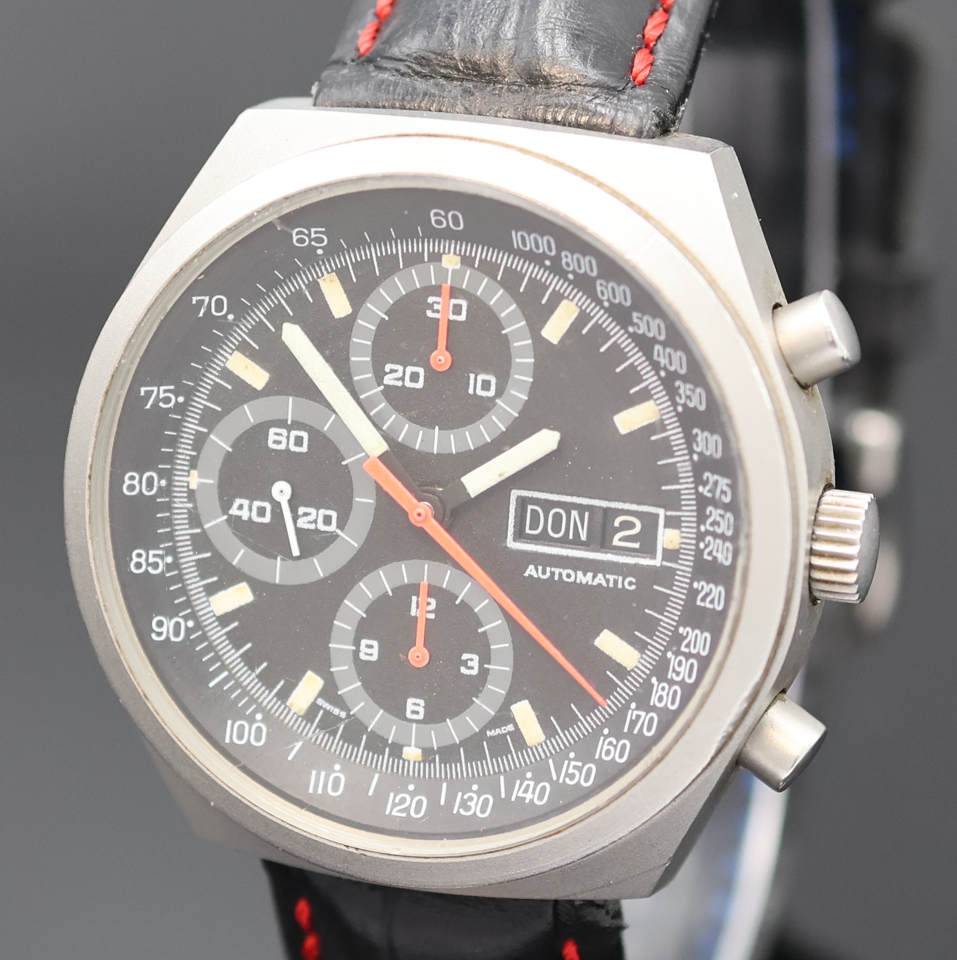 Detail a: Armbandchronograph in mattiertem Stahlgehäuse, Schweiz um 1980, Automatik, 2-tlg. Geh., Boden verschr., schwarz. Zifferbl., Leucht- indizes u. ...