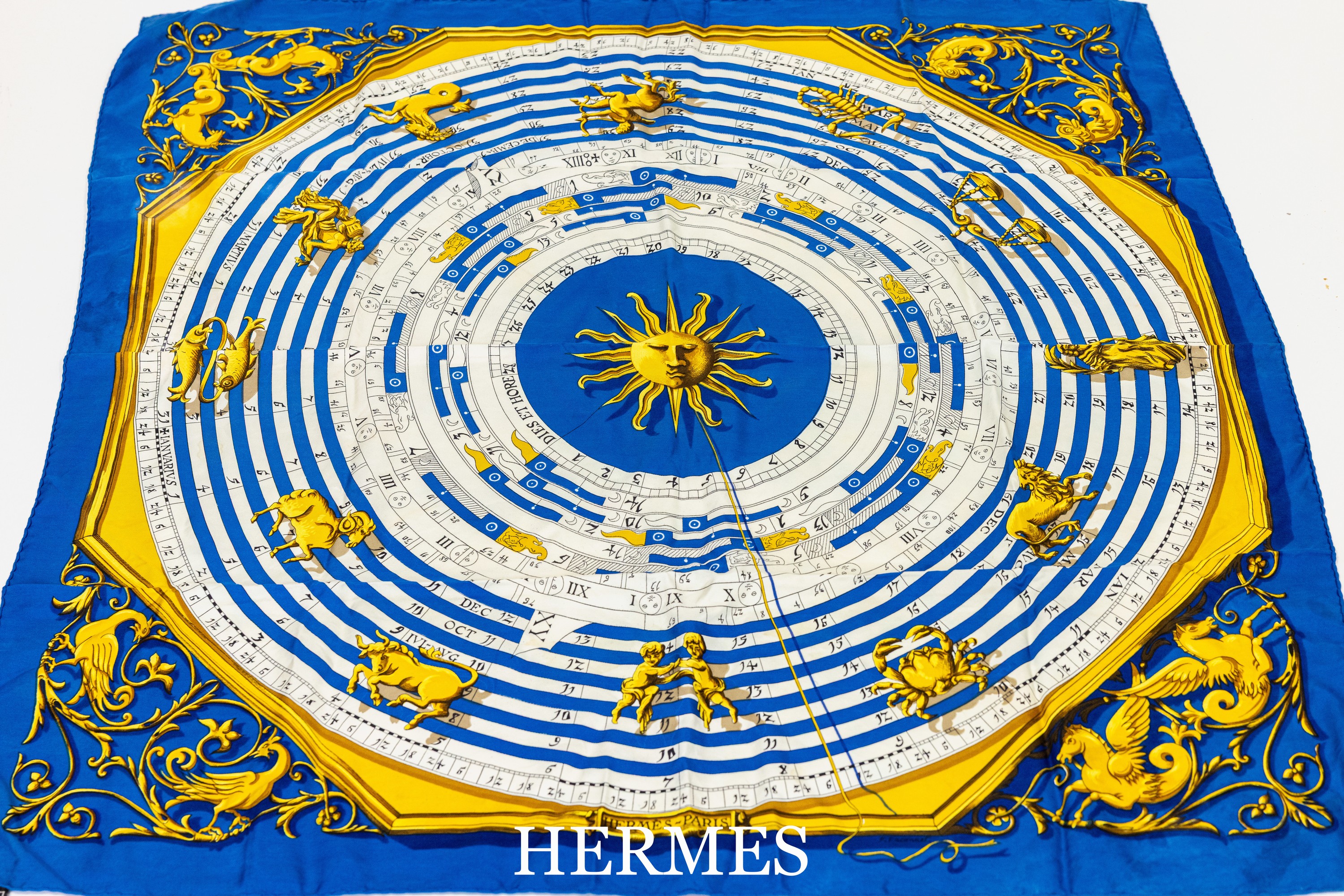 HERMES Seidencarree, 100% Seide, "Echarpe Horoscope", Grund in Weiß und Blau, goldfarb. Motive, ca. 88 x 88 cm, Rand handrolliert, z.T. ...