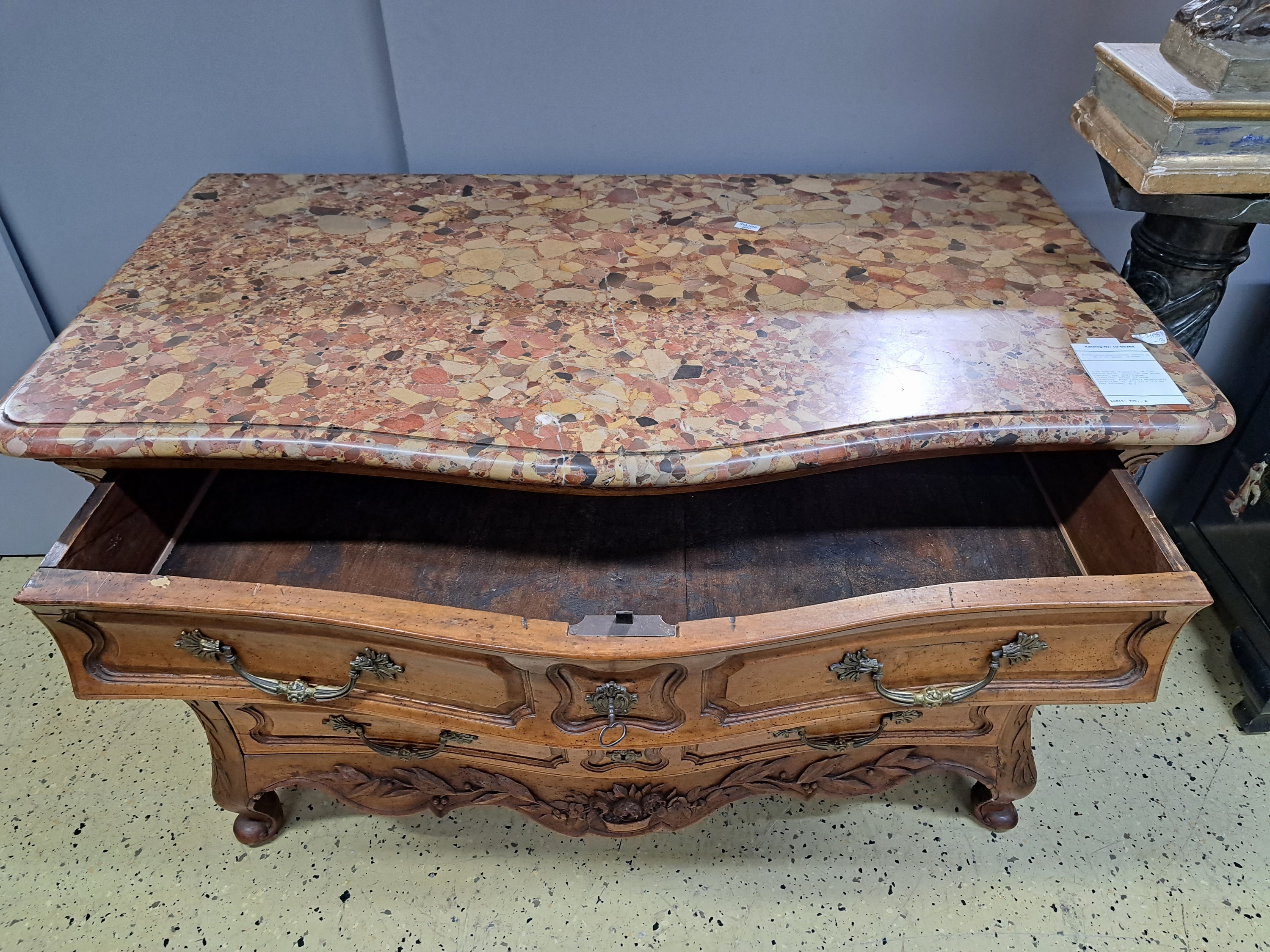 Detail d: Große Kommode, Frankreich, um 1760, Nußbaum massiv, geschweift und leicht bombiert, drei große Schübe, kassettiert, Seiten und Zarge beschnitzt, ...