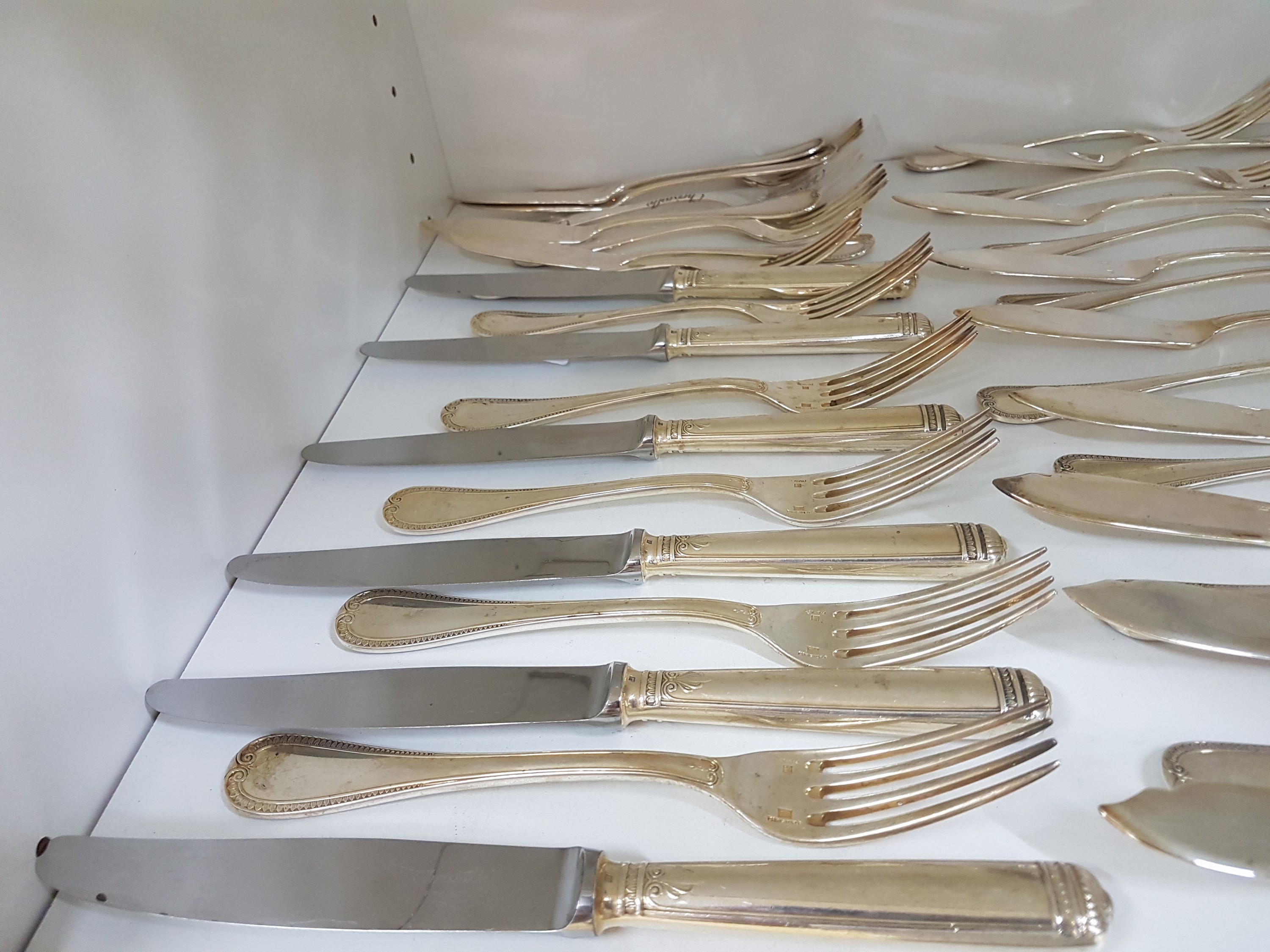 Detail c: Besteck und Teller, Christoffle, Besteck Malmaison, 6 Messer, 5 Menuegabeln, 12 Fischmesser, 12 Fischgabeln, 5 Suppenlöffel, 5 Kaffeelöffel, dazu 4 ...