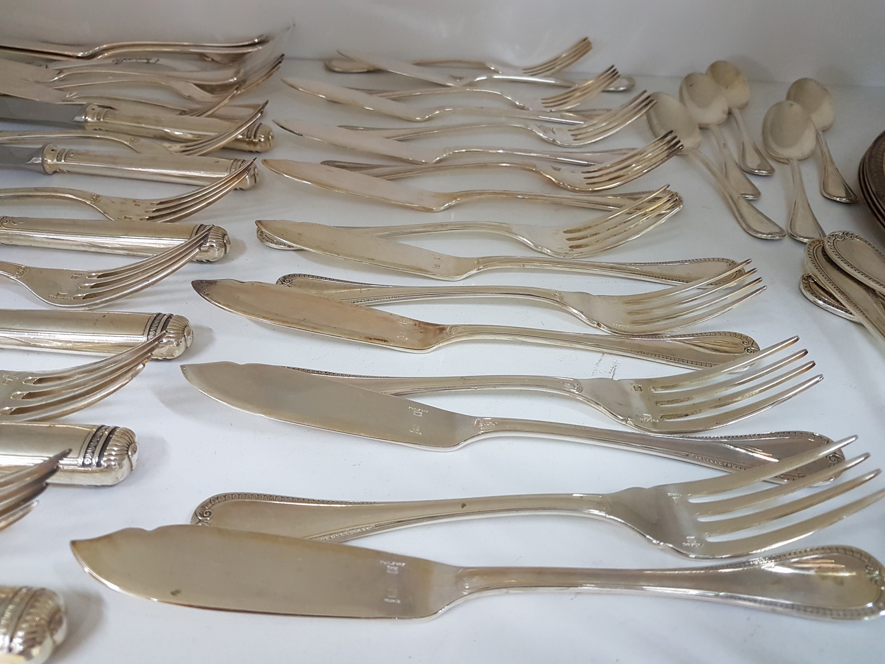 Detail d: Besteck und Teller, Christoffle, Besteck Malmaison, 6 Messer, 5 Menuegabeln, 12 Fischmesser, 12 Fischgabeln, 5 Suppenlöffel, 5 Kaffeelöffel, dazu 4 ...