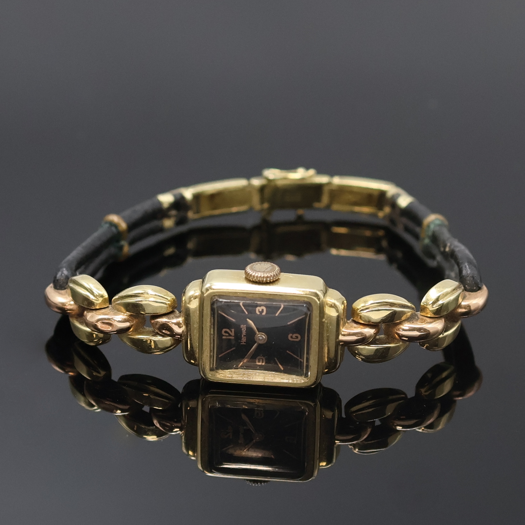 HERWALT Damenarmbanduhr in GG 585/000, Schweiz um 1955, Handaufzug, Scharnierboden, schwarzes Zifferbl. m. arab. Zahlen u. Strich-Ind., gold. Zeiger, ...