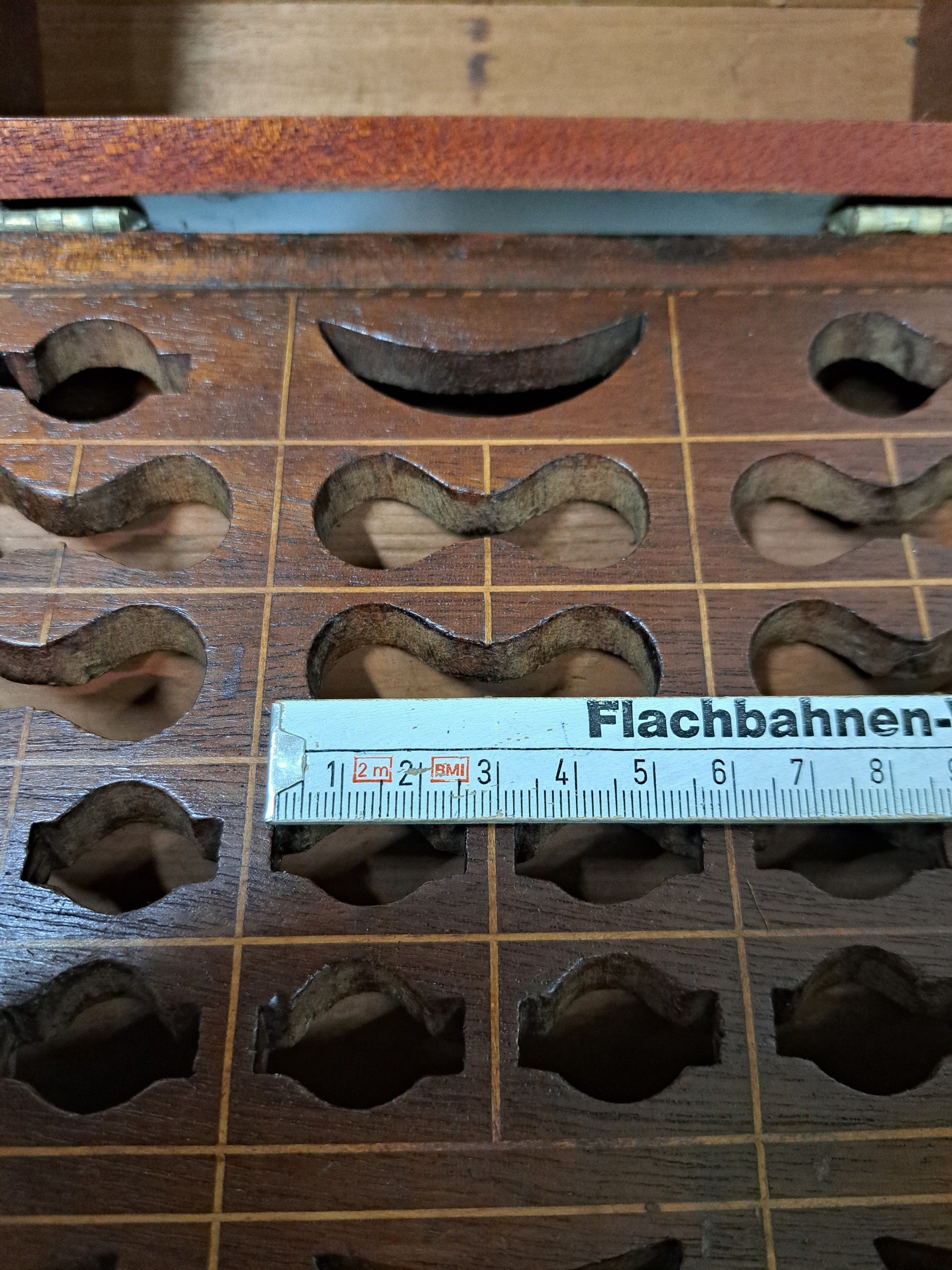 Detail o: Besteckkasten, wohl englisch, Ende 19. Jh., Nußbaumfurnier mit Fadenintarsien, im Deckel Stern, Öffnungen für ein Besteck 12 Personen (Messer, ...
