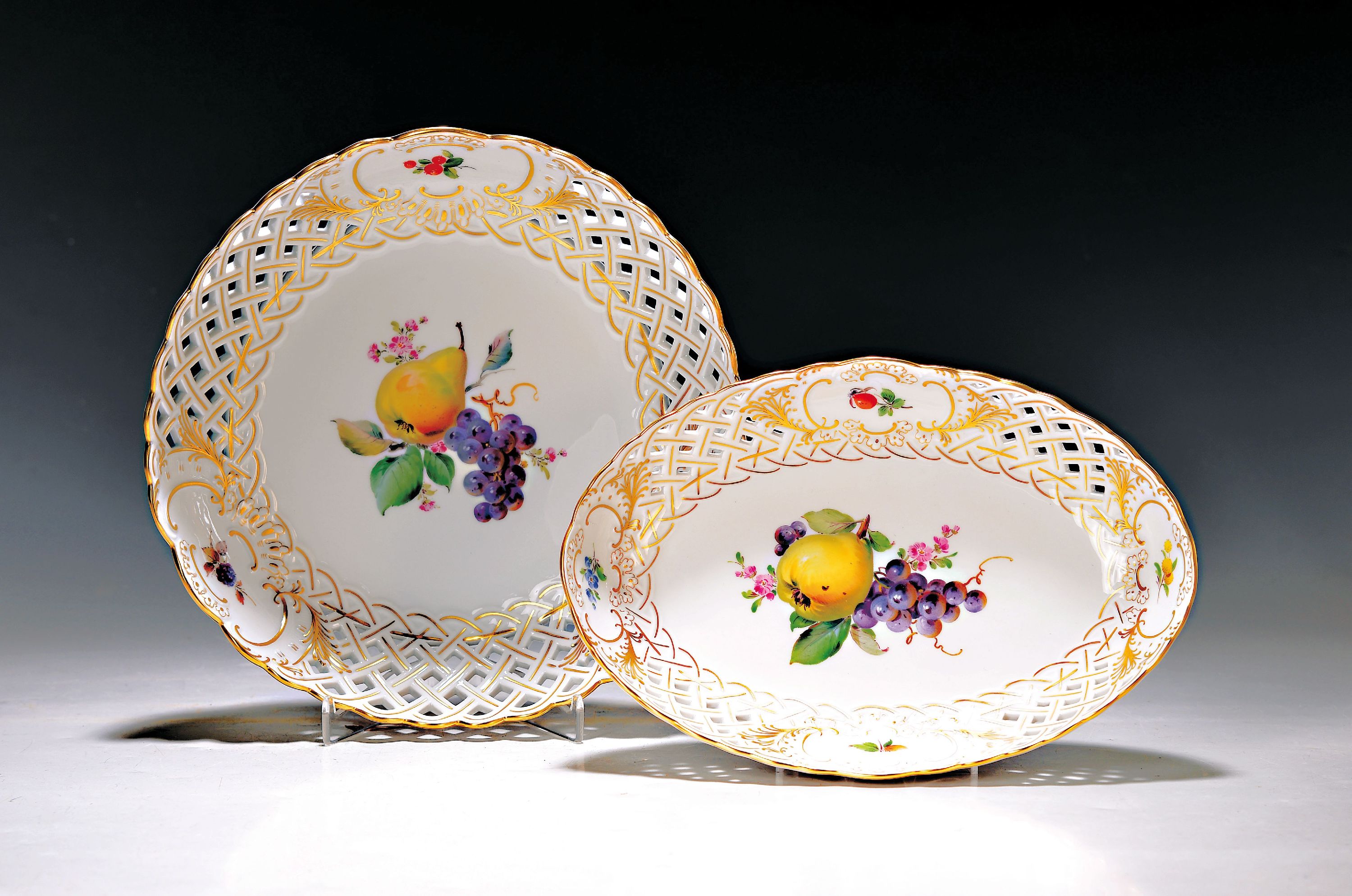 2 Schalen, Meissen, 20. Jh., 1. Wahl, Rand in Durchbrucharbeit mit Goldstaffage, mittig bunt bemalt mit Obstbukett, 1x H. ca. 5cm, D. ca. 24cm, 1x ...