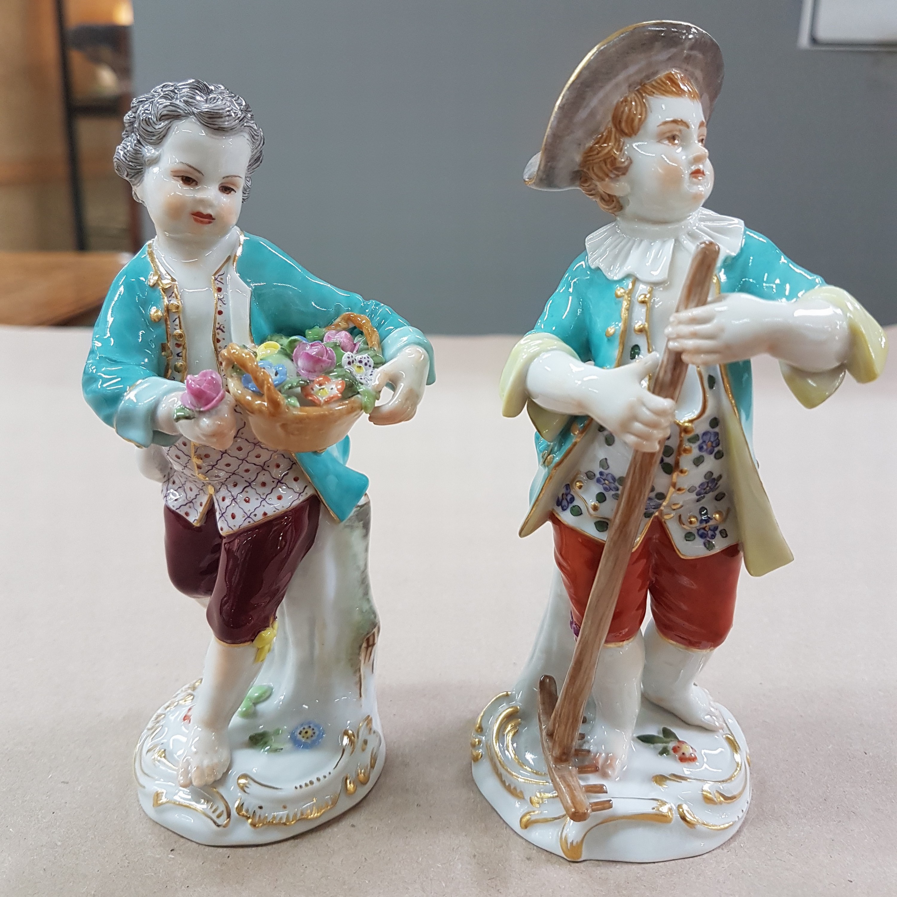 Detail a: 2 Porzellanfiguren, Meissen, 20. Jh., 1. Wahl, Gärtnerkinder mit Rechen bzw. Blumenkorb, bunt bemalt, Goldstaffage, H. ca. 13 bzw. 13.5cm