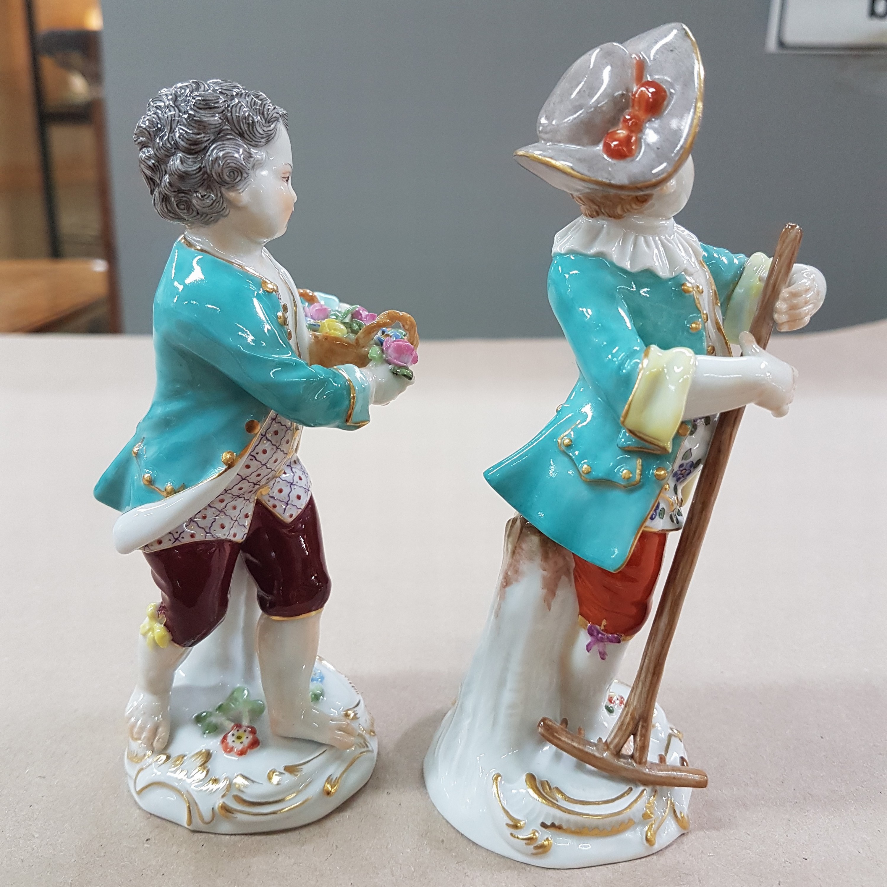 Detail c: 2 Porzellanfiguren, Meissen, 20. Jh., 1. Wahl, Gärtnerkinder mit Rechen bzw. Blumenkorb, bunt bemalt, Goldstaffage, H. ca. 13 bzw. 13.5cm